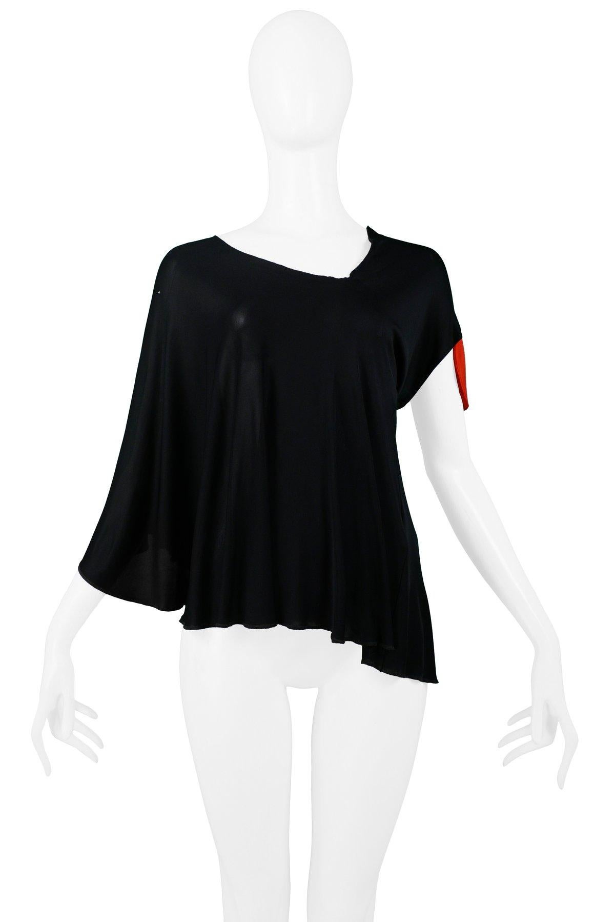 Resurrection is pleased to offer a vintage Maison Martin Margiela black rayon jersey top featuring an angled neckline, asymmetrical draped cape-style sleeve, and red target detail.

Maison Martin Margiela
Size Medium
Viscose Rayon
1997 Collection