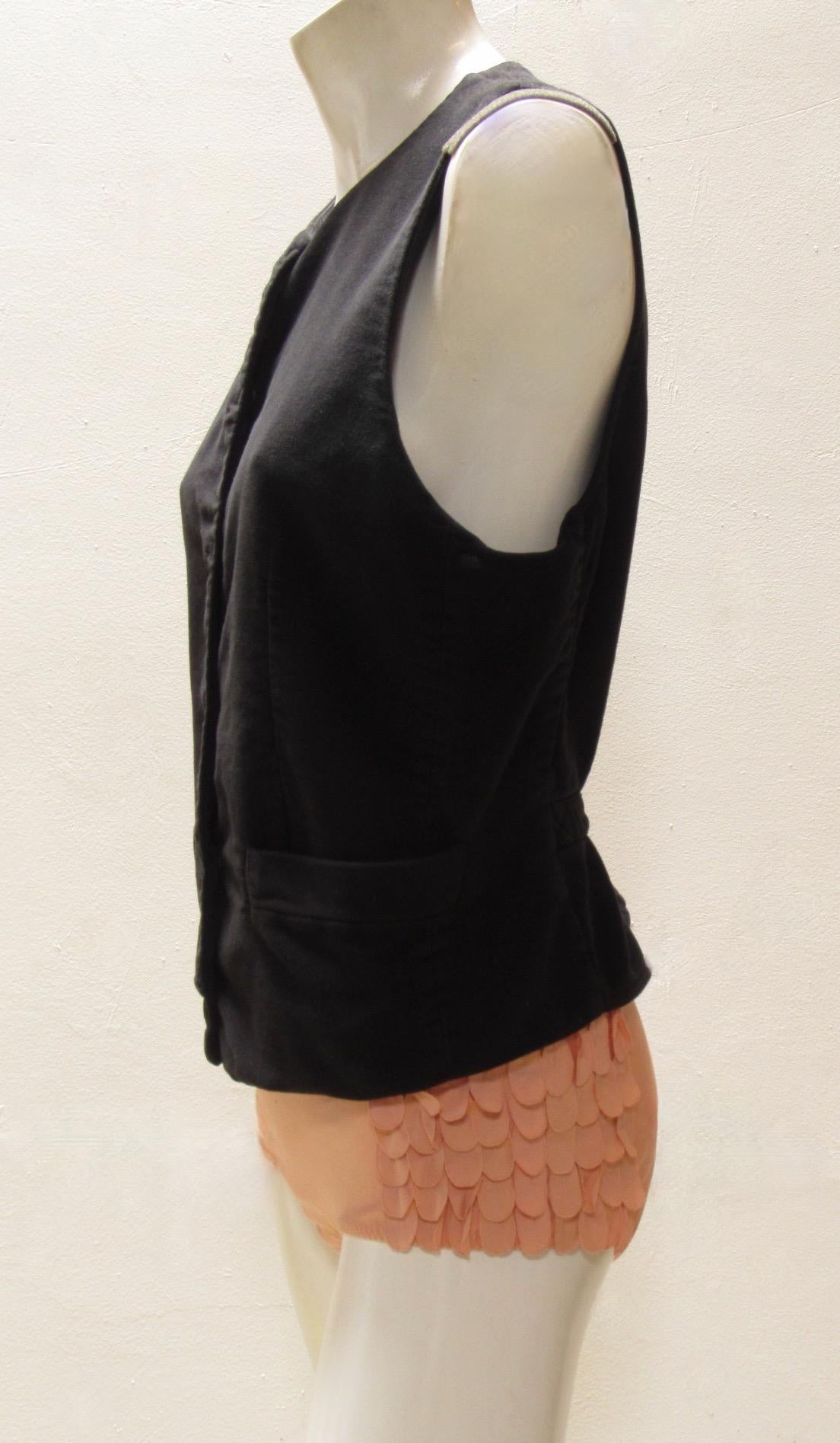 This black vest from Maison Martin Margiela is a soft cotton flannel. Easy fastening with a snap front and buckle and strap in back to personalize the fit. 