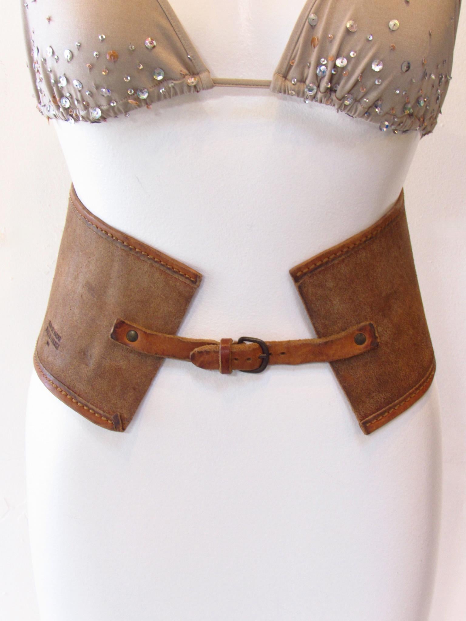 Vintage Maison Martin Margiela brown cowhide belt is rugged with sturdy straps in front that buckle closed. The wide band measures 24 inches. The complete width, including fasting straps, measures 30 inches from end to end. It is quite small.