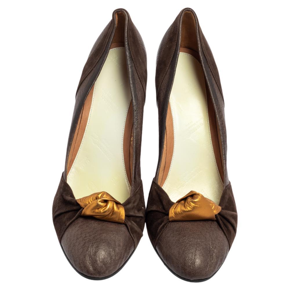 Make a chic style statement as you flaunt these Maison Martin Margiela pumps. They come crafted from brown suede & leather and feature rounded toes. They have been styled with knot detailing on the uppers and come with 10 cm wedge heels.

Includes: