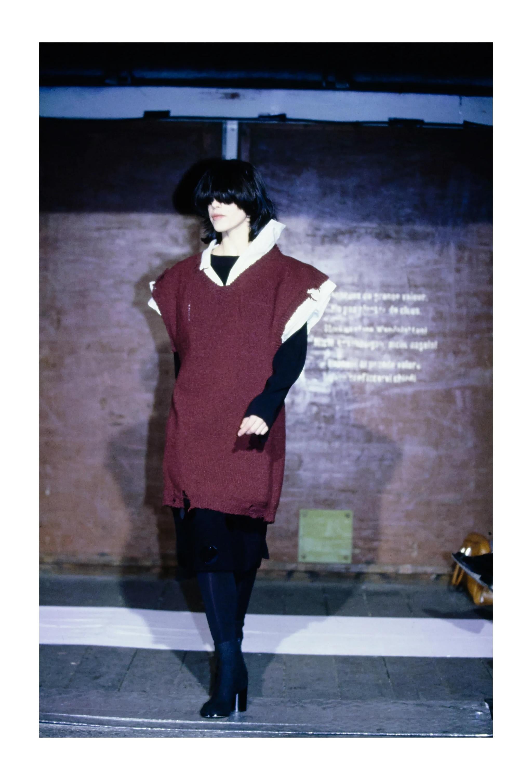 Resurrection Vintage è entusiasta di presentare un maglione vintage Maison Martin Margiela bordeaux oversize della collezione Autunno 2000, che enfatizza le proporzioni esagerate. Questo maglione presenta un profondo scollo a V, spalle larghe,