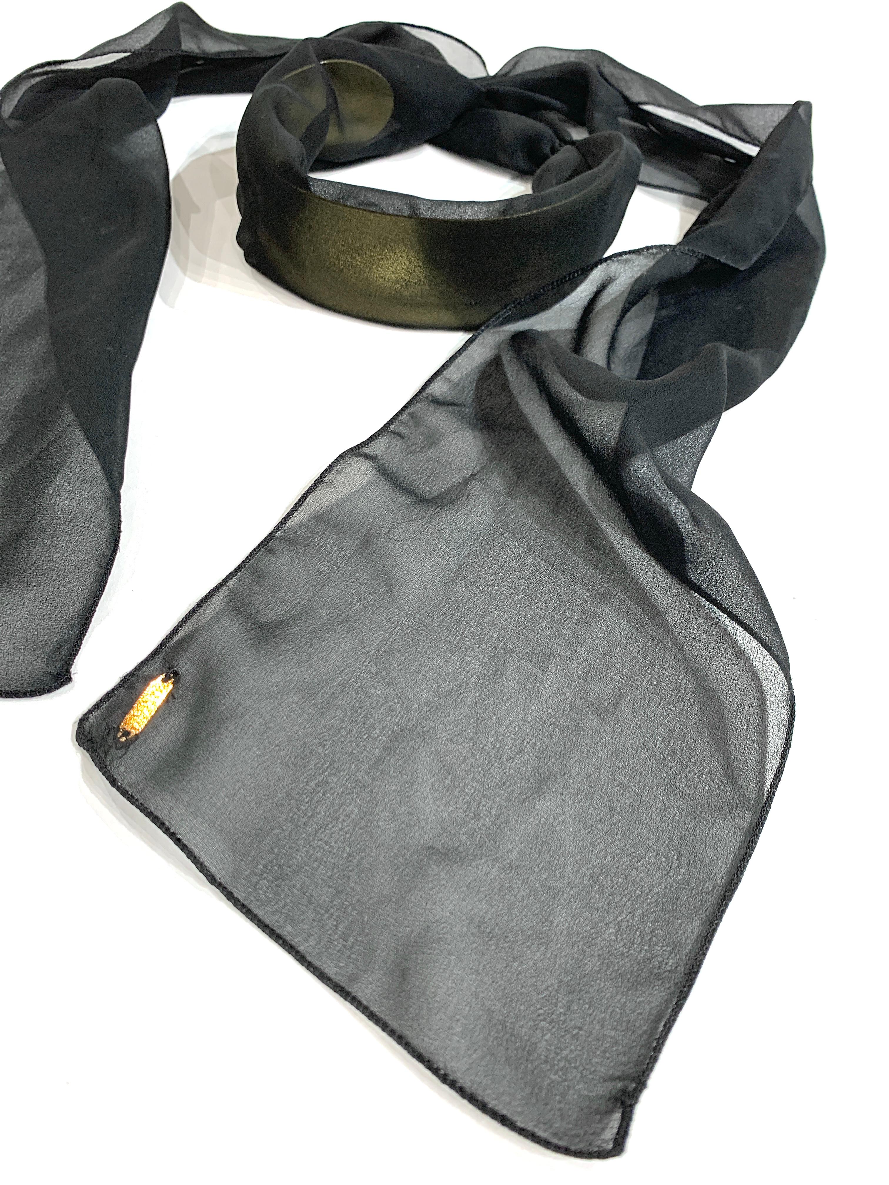 Maison Martin Margiela - Dark gold-colored satin brass chocker covered with a black silk overlay. The brass necklace is locked with stitching from the silk lining. The necklace is closed by knotting the silk around the neck. On one end of the