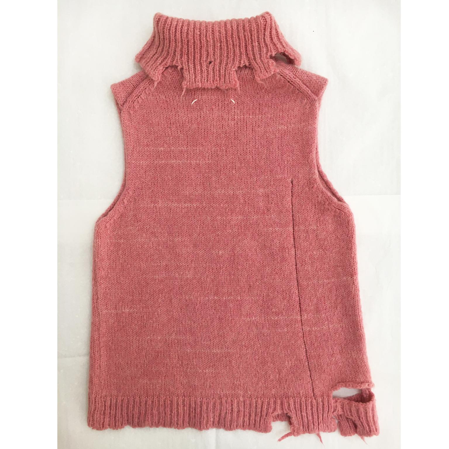 Maison Martin Margiela destroyed pink sleeveless knit from collection A/F 2000.
All the destroyed wholes including on the front panel are secured as part of the design. 
Shoulder : 37 cm
Back length 67 cm
Underarm : 42 cm
