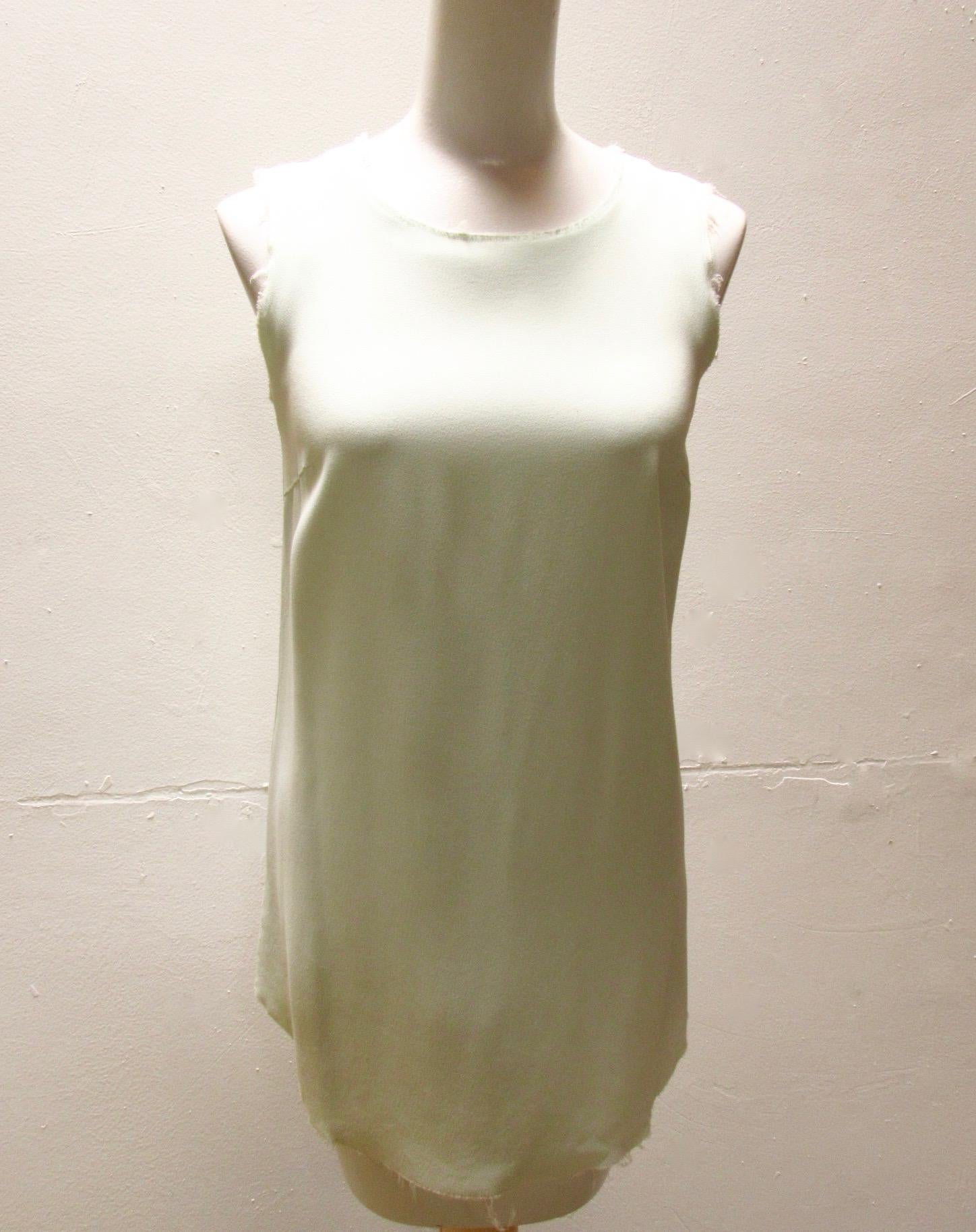 Mint green deconstructed top from Maison Martin Margiela Archive. This 20th century top features a round neck, a keyhole back with a single button closure at the nape, and frayed edges throughout. Has a longer round front hem. 