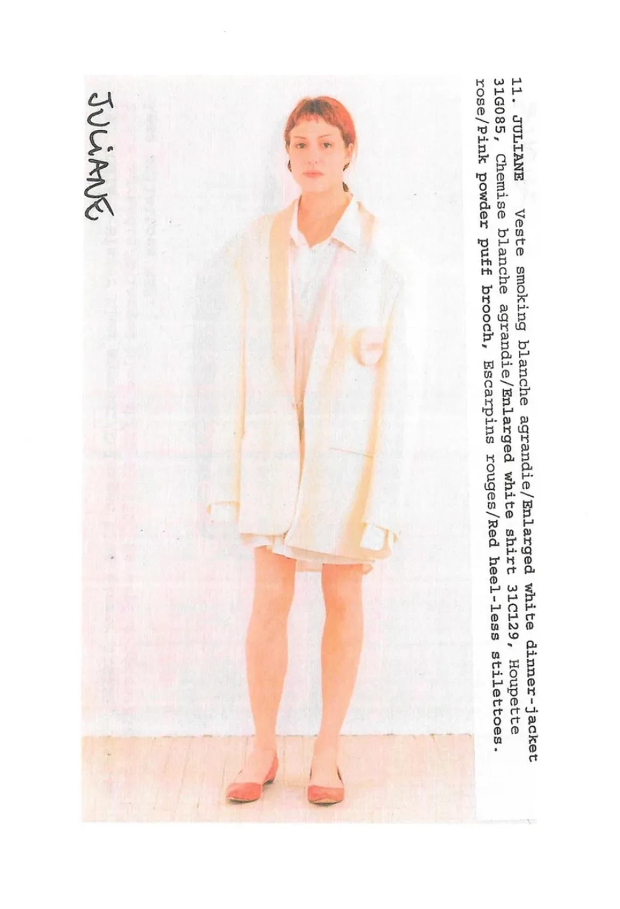 Resurrection Vintage se complace en ofrecer un broche vintage de polvera de Maison Martin Margiela, con una banda de satén en la parte delantera que imita una polvera real, cierre metálico dorado en la parte trasera y la inscripción 