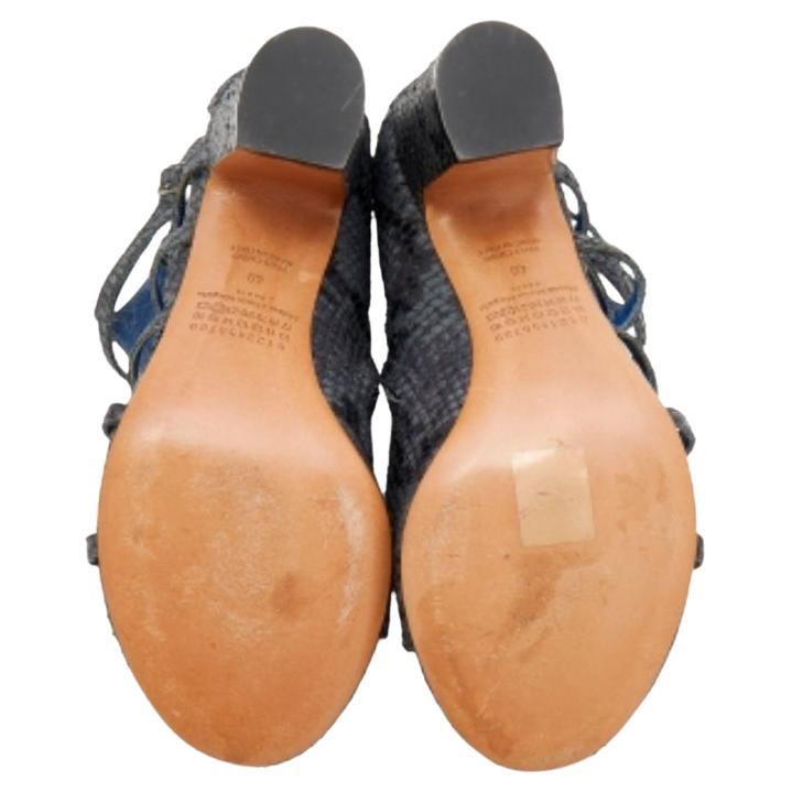 Lascia passi audaci e sicuri quando esci con questi stivaletti di Maison Martin Margiela. Realizzate in pelle goffrata di pitone, sono dotate di tomaia con cinturino, chiusura con cerniera ai lati e tacco di 7,5 cm.
