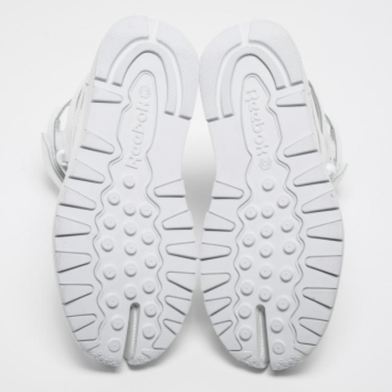 ¡Unas zapatillas estilo gladiador de la colaboración de Maison Martin Margiela con Reebok! Estas zapatillas Tabi de caña alta son de piel blanca, presentan la famosa puntera 