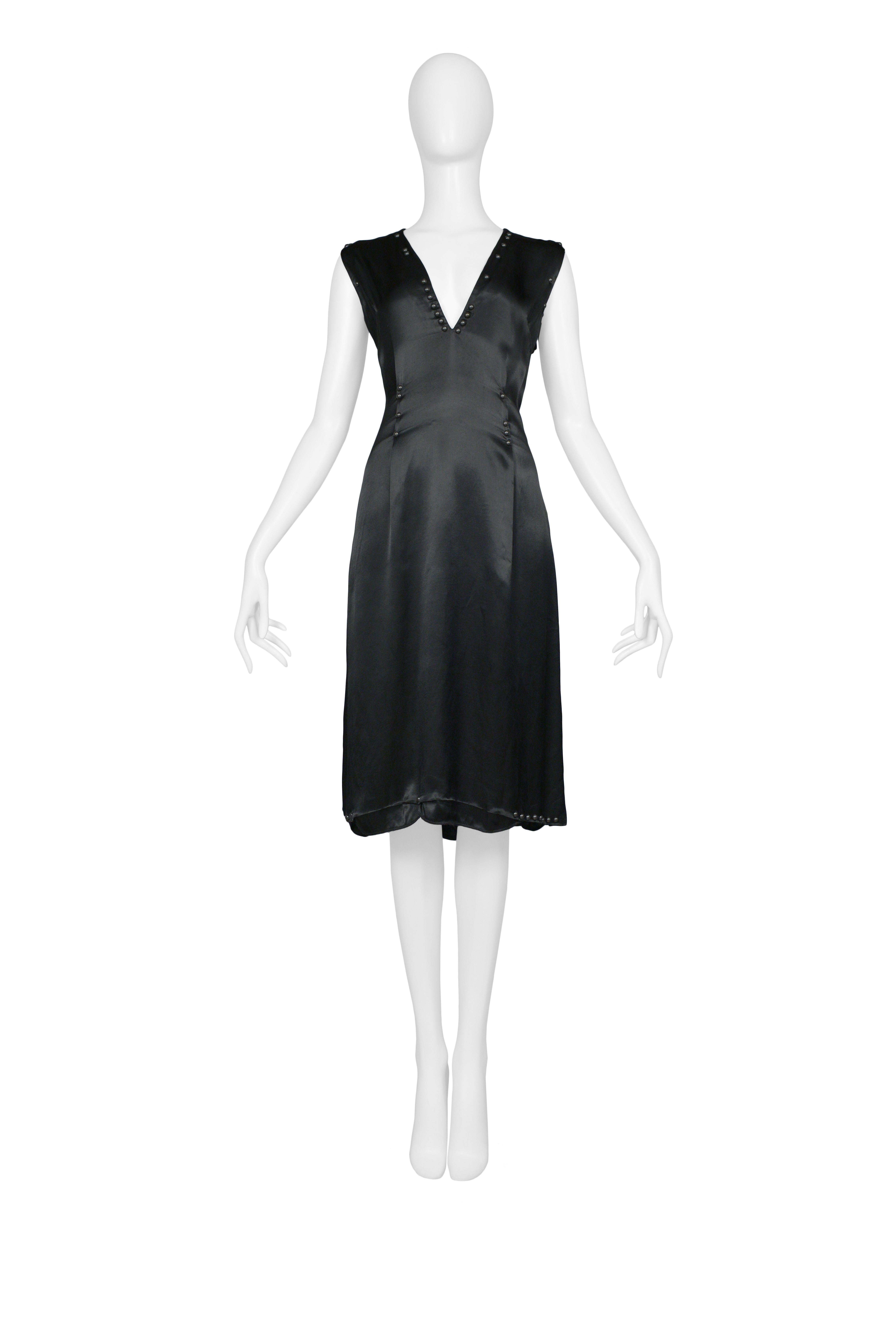 Resurrection Vintage is excited to offer a vintage Maison Martin Margiela black satin dress with a v neckline that is decorated with studs, an unlet hem with studs, and inspired by car seat covers from the infamous car seat collection. Made in
