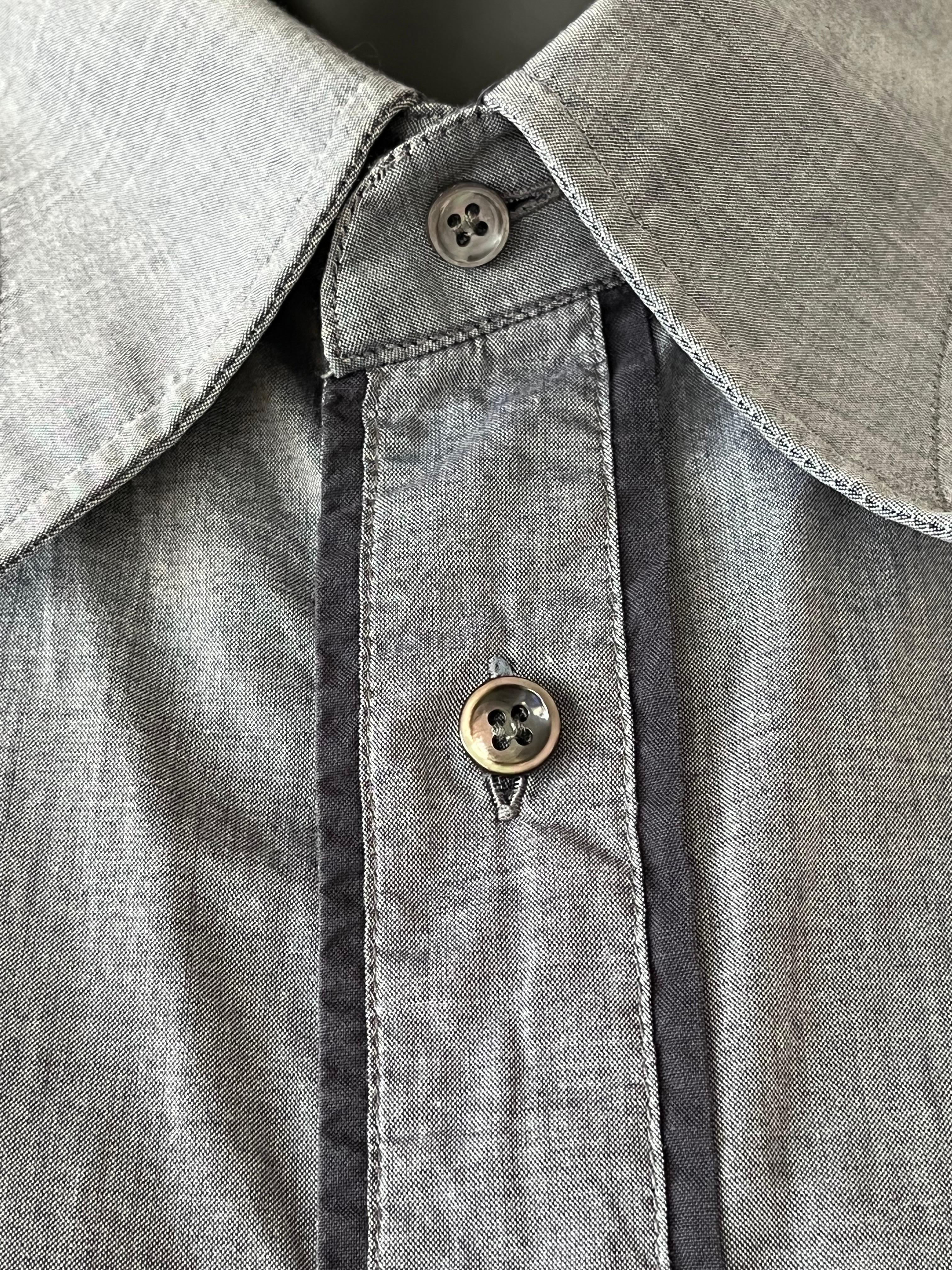 Chemise pour homme de Maison Martin Martin en gris pâle et bordures noires contrastées. Pièce iconique en très bon état.