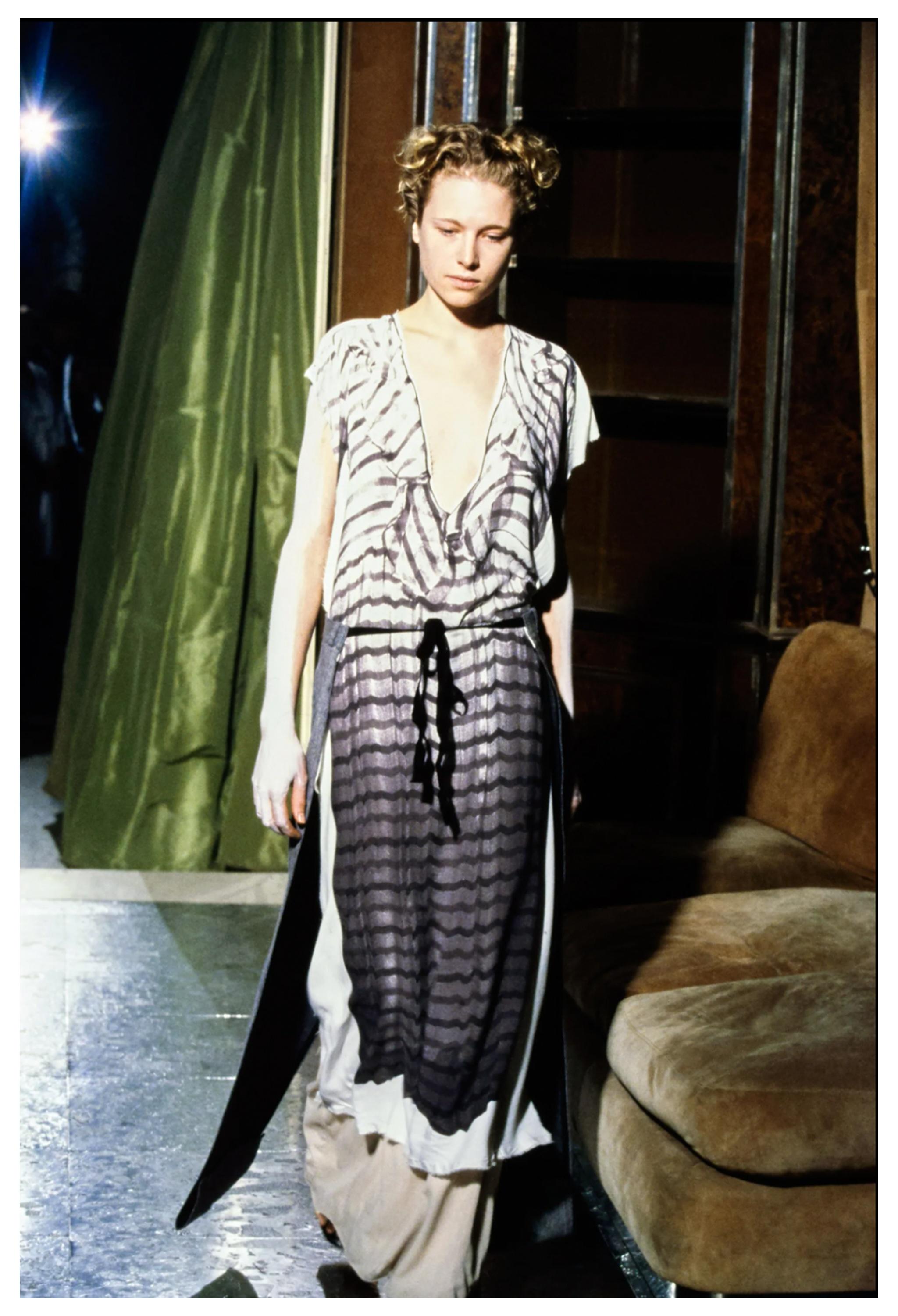 Resurrection Vintage è entusiasta di offrire un abito vintage Maison Martin Margiela iconico tromp l'Oeil con una stampa fotografica in tonalità seppia di un abito vintage stampata su un semplice maxi abito a rete in stile caftano. 

Maison Martin