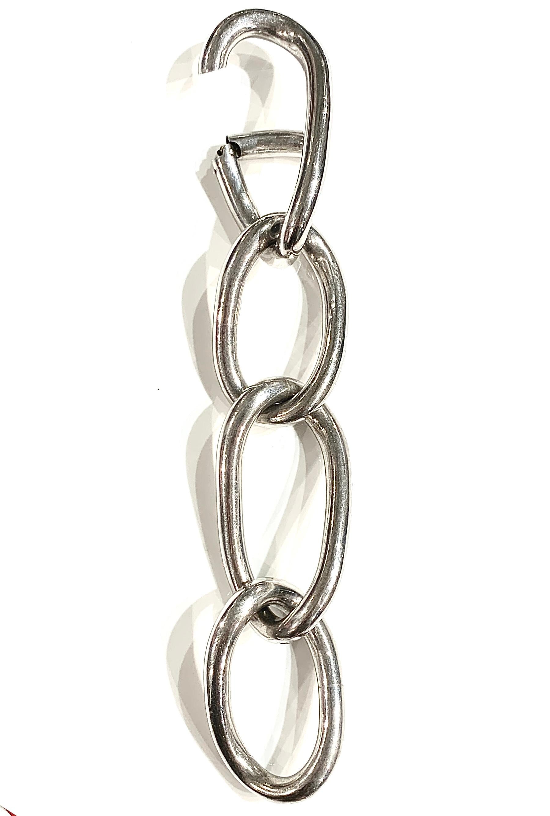 Set of 925 silver maxi chains designed in 2008 by Martin Margiela in collaboration with Damiani. The set consists of a necklace, a ring and a bracelet on which Maison Martin Margiela's brand name is displayed.
The ring is composed of four rings