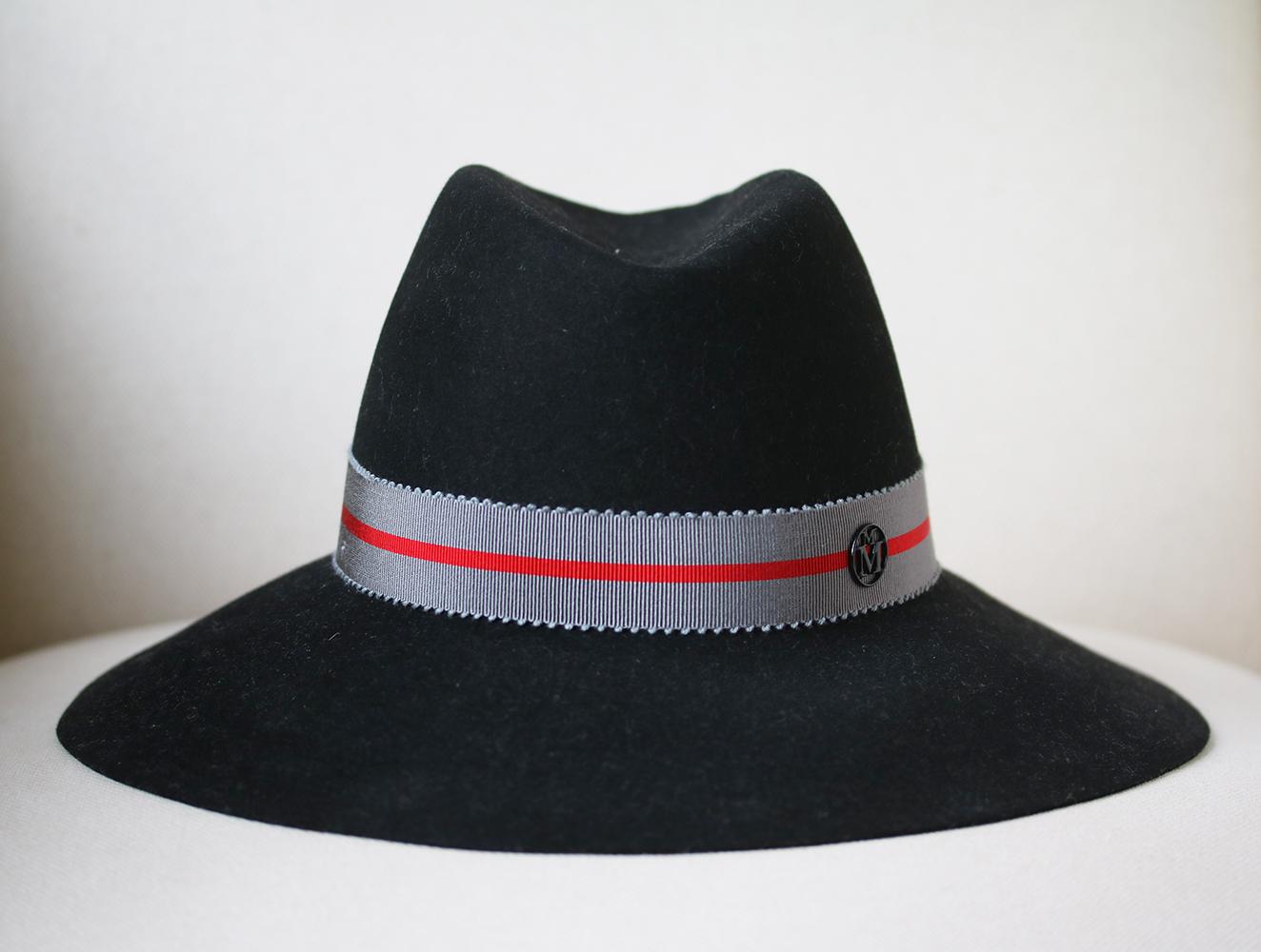 This Maison Michel hat is rendered in rabbit felt and features a two tone band. Two tone band. Wide brim. Composition: Rabbit felt. Colour: black. Slip on. Made in France. 

Size: Medium (Circumference - 56 cm, Brim depth - 8 cm)

Condition: As new