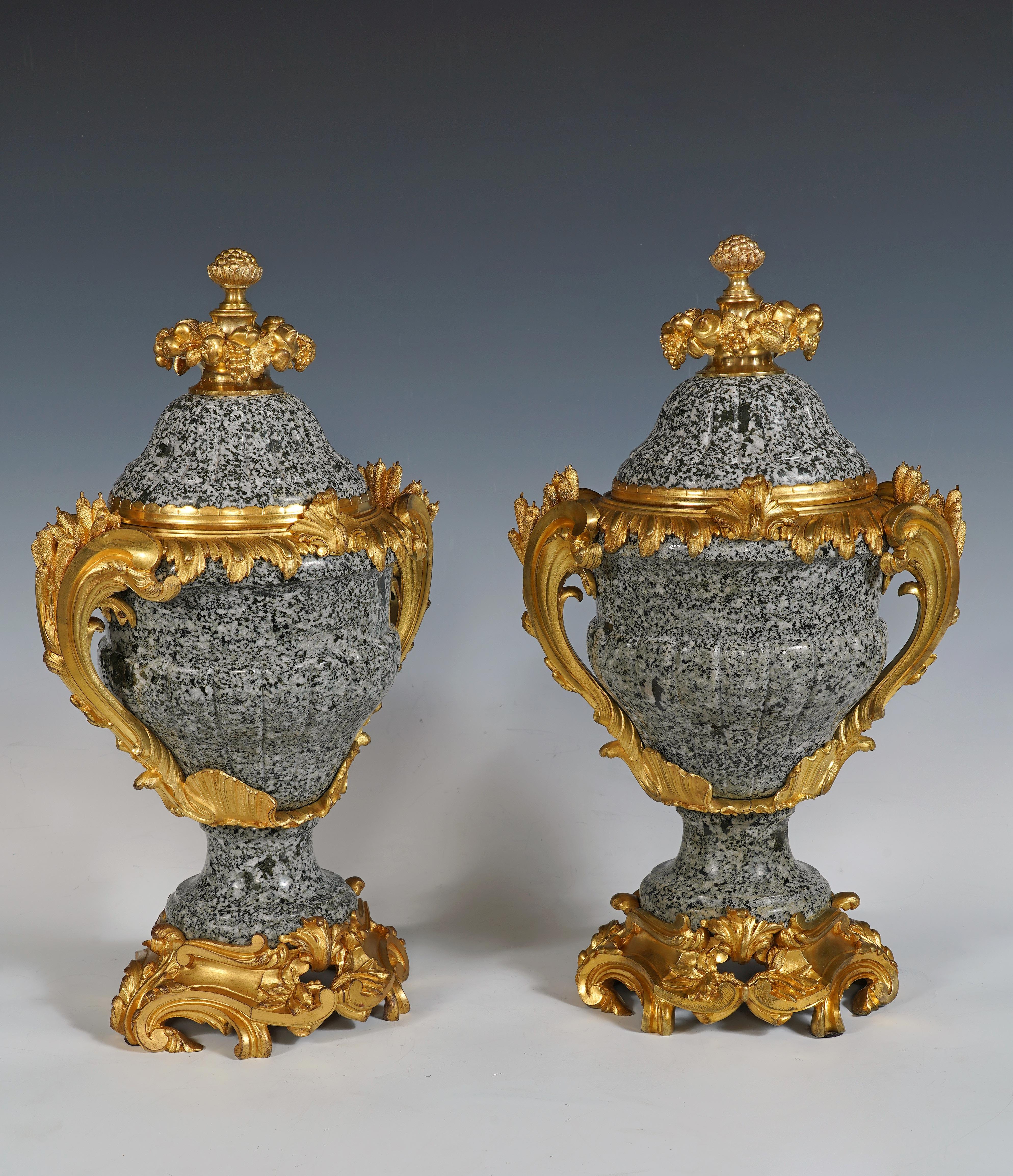 Pair of Louis XVI-inspired curved shape cassolettes with godrons, in green granite and chiseled and gilded bronze, in the Rocaille style, attributed to Maison Millet. The lid is topped by a pomegranate surrounded by pine cones, grapes and