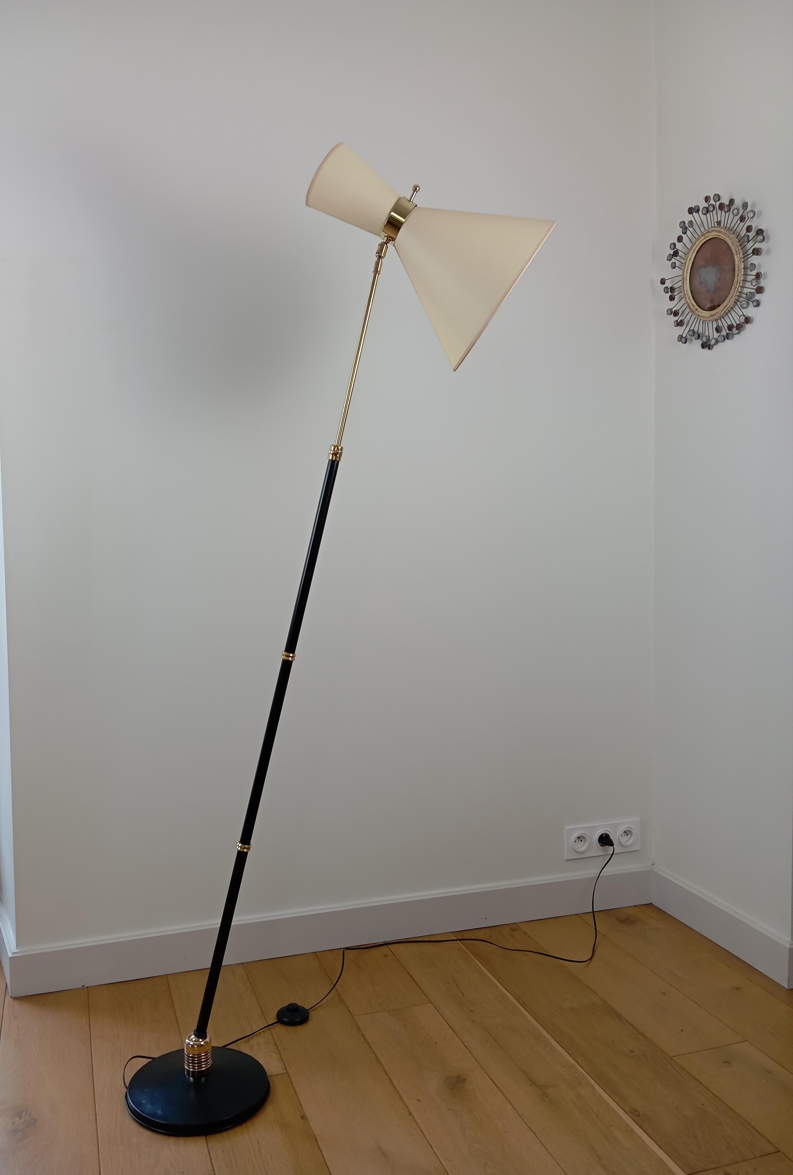 Metal and brass floor lamp,
comprising a circular base in black lacquered metal and cast iron,
on which is mounted an extendable light arm in black lacquered metal and brass.
A ball joint between the base and the arm allows the floor lamp to be
