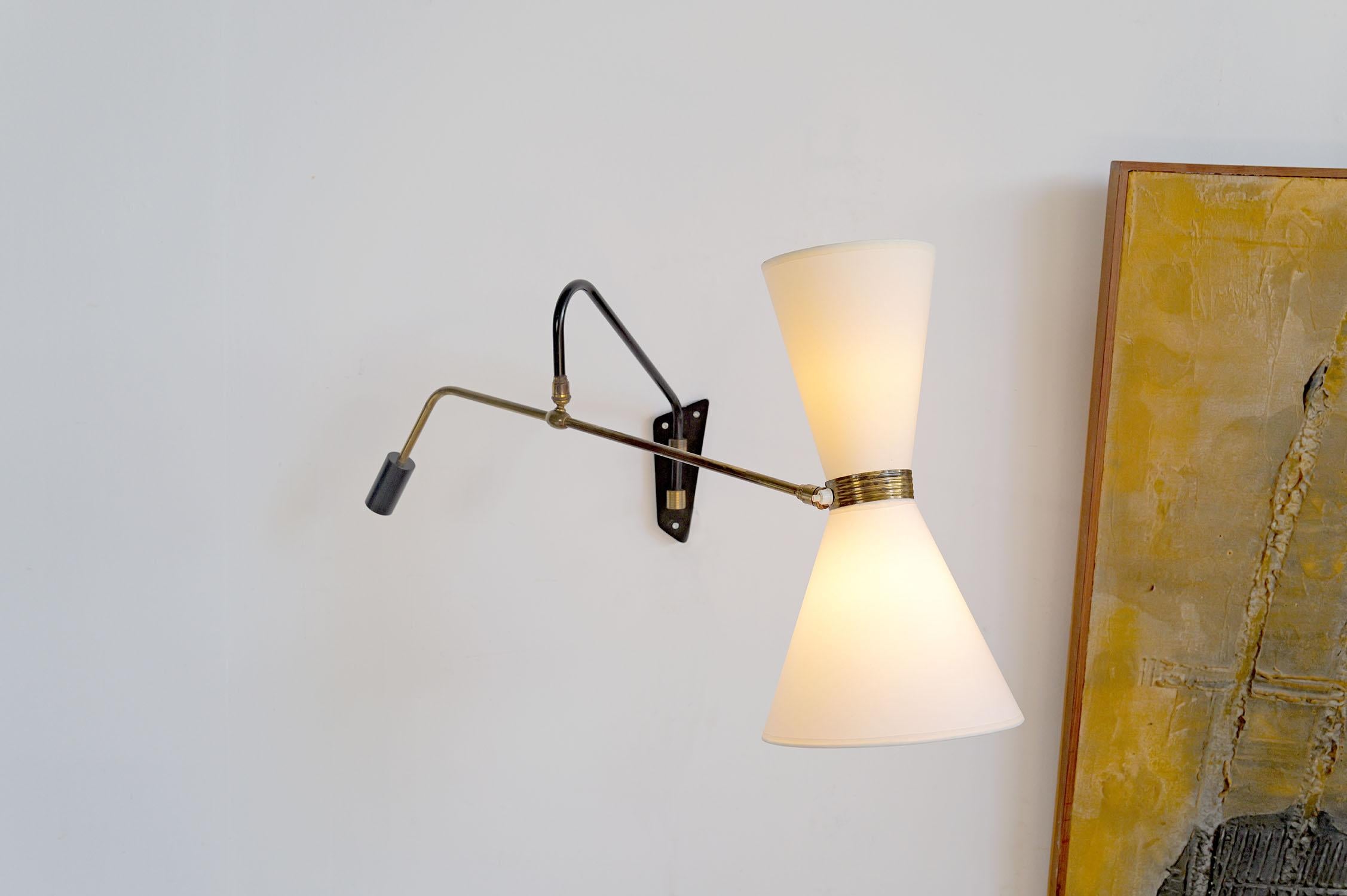 Maison Maison Monix, rara lampada da parete in metallo laccato nero e ottone dorato, Francia 1960. Grazie al sistema a doppio braccio, combinato con due giunti a sfera e un contrappeso, questa lampada può assumere un'ampia varietà di posizioni. Le