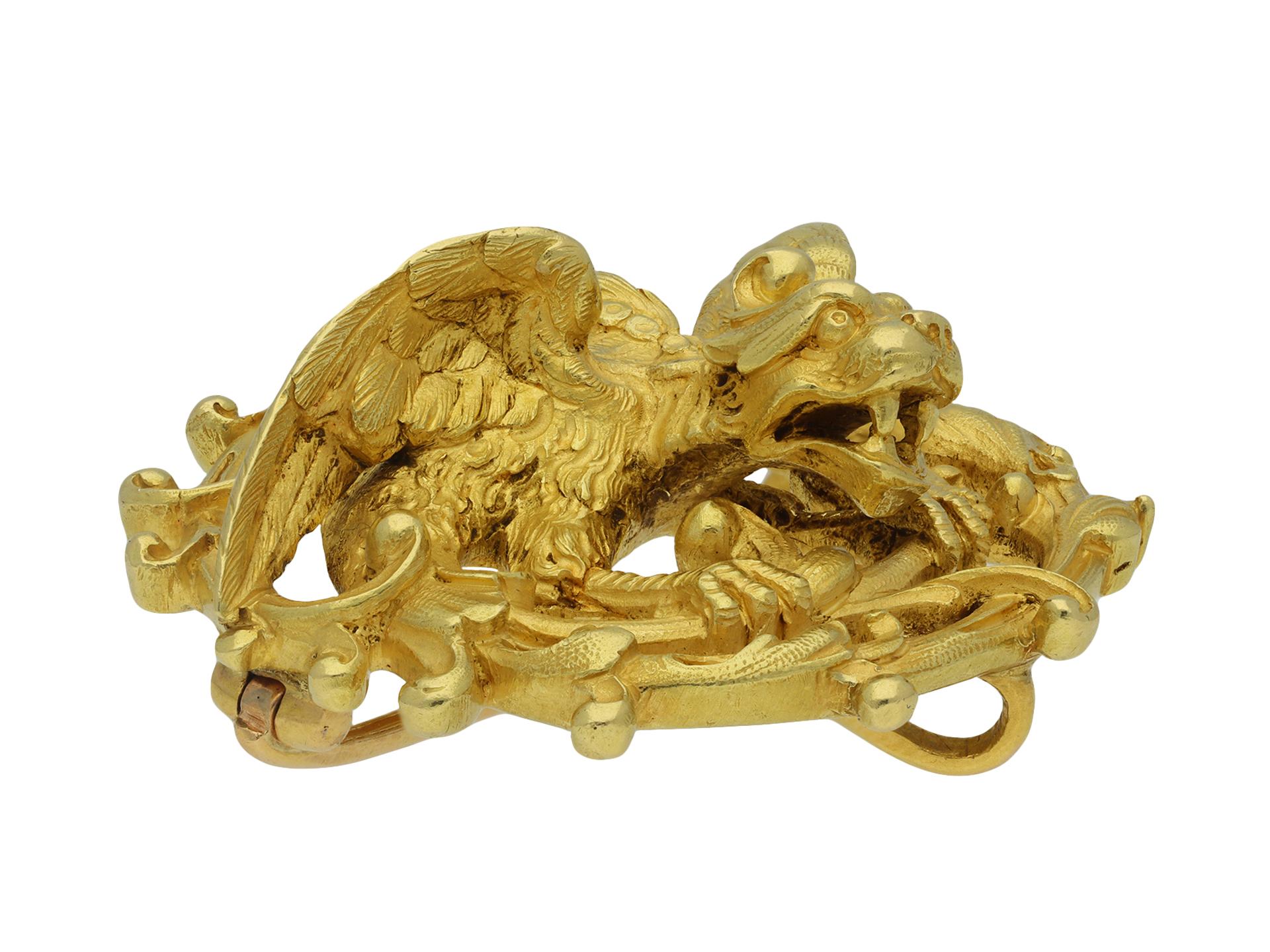 Maison Plisson et Hartz chimera brooch. A circular yellow gold brooch, composed of an intricately carved crouching chimera with teeth bared and wings unfurled, encircled by a swirl of openwork scrolling foliage, with fine engraved detailing