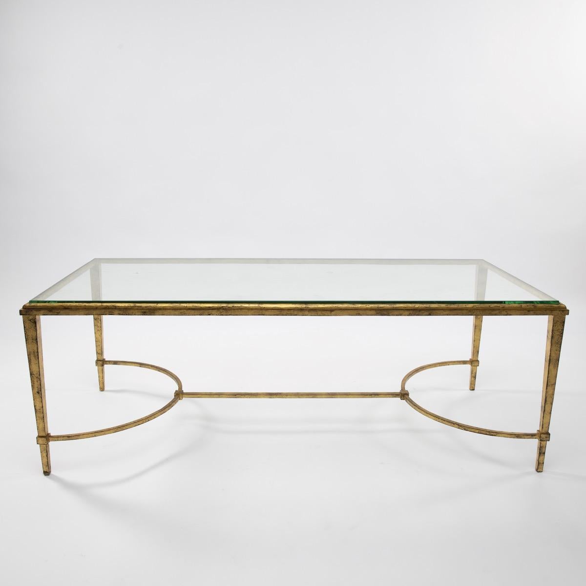 A midcentury golden iron cocktail or coffee table designed and manufactured by Maison Ramsay, Paris, France, circa 1950-1960. Very clean and sharp lines, the table structure is made from two thin semi-circular stretcher and a glass, all in beaten