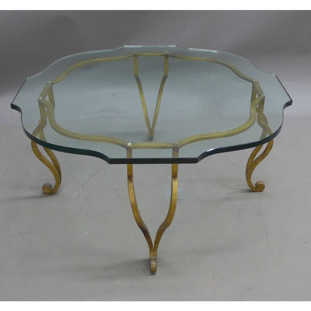 Maison Ramsay Classic Line Gilt Iron and Glass Top Low Table. Stylized coffee/cocktail table. Gilded wrought iron base with four curving legs and scalloped glass top.