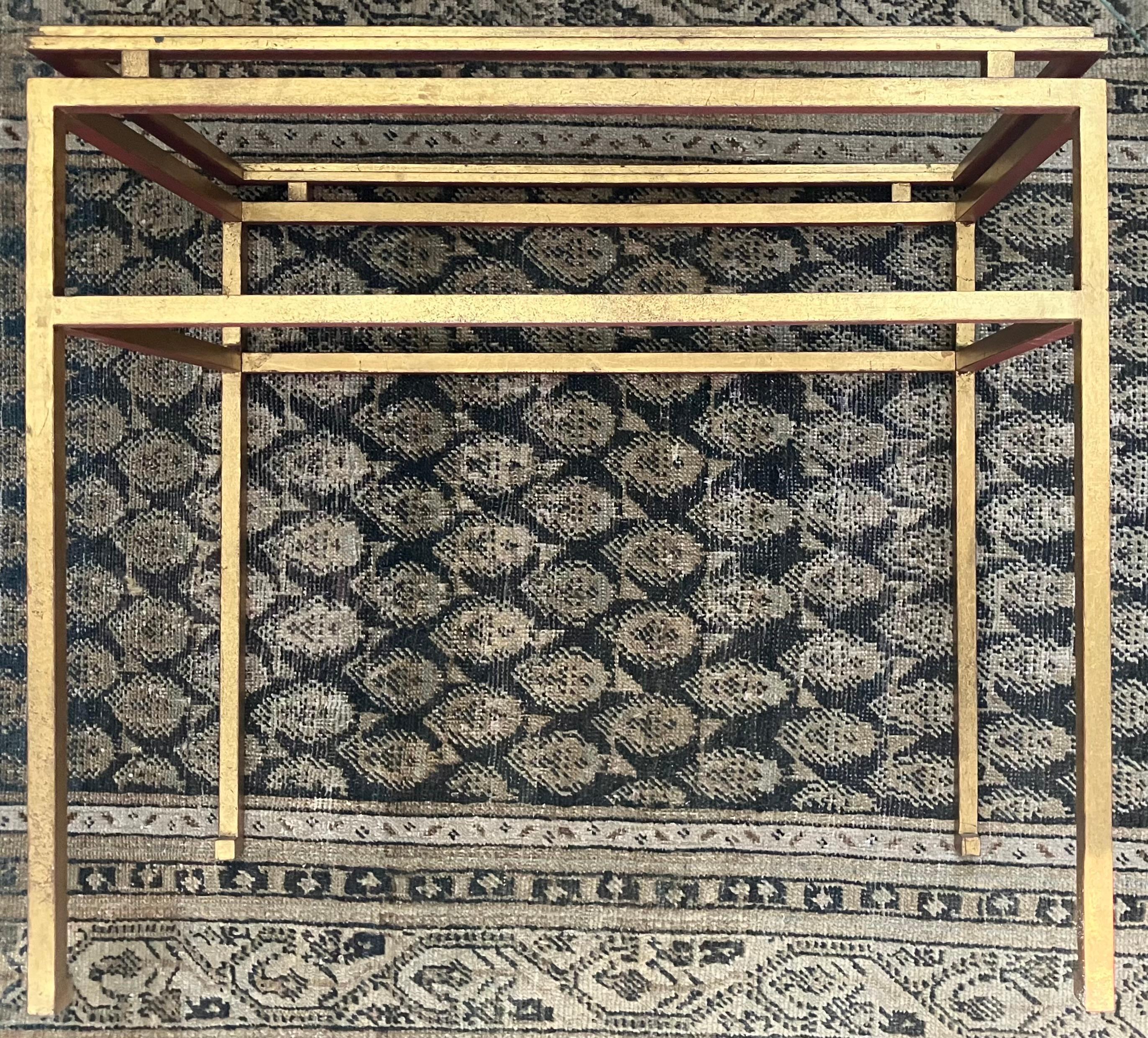 Maison Ramsay Gilt Iron Table. French gilt wrought iron  table in a classical Etruscan manner with enframed glass top floating on gilt spacers above severe rectilinear body with turned in feet, all signatures of Ramsay and very translatable to