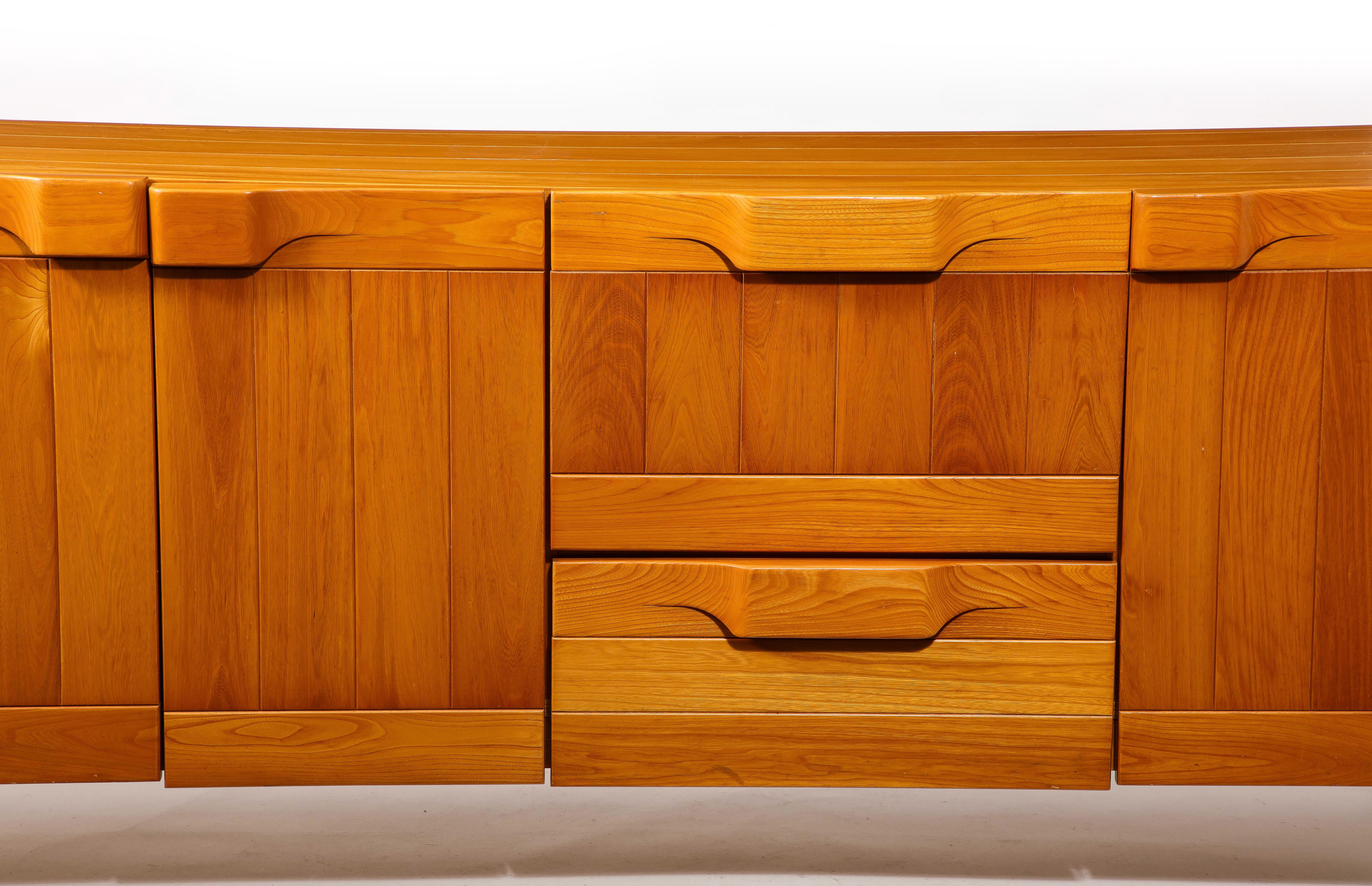 Large solid Elm credenza by Maison Regain with multiple compartments, drawers, and a lit-up bar.
