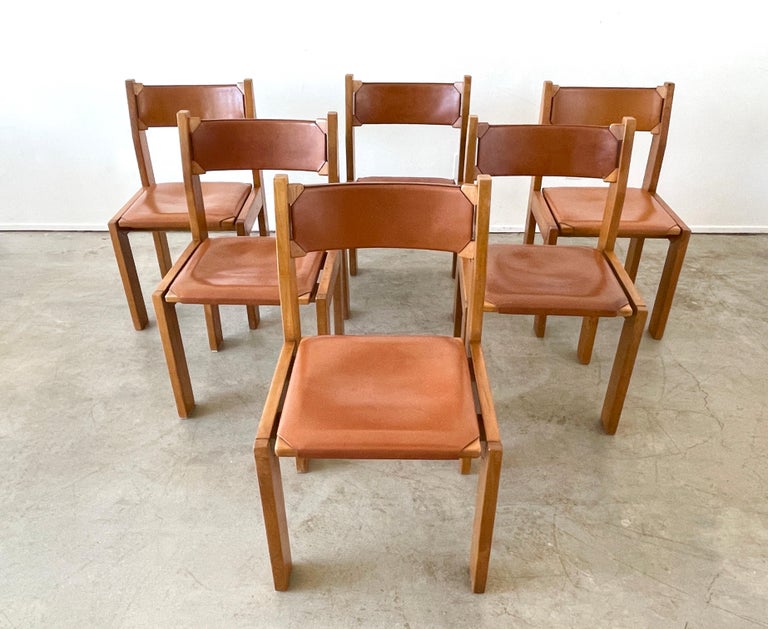 Maison Regain leather and elm wood chairs with extra cushioned seats. 
Great patina to leather and solid construction in the style of Pierre Chapo
Priced individually.