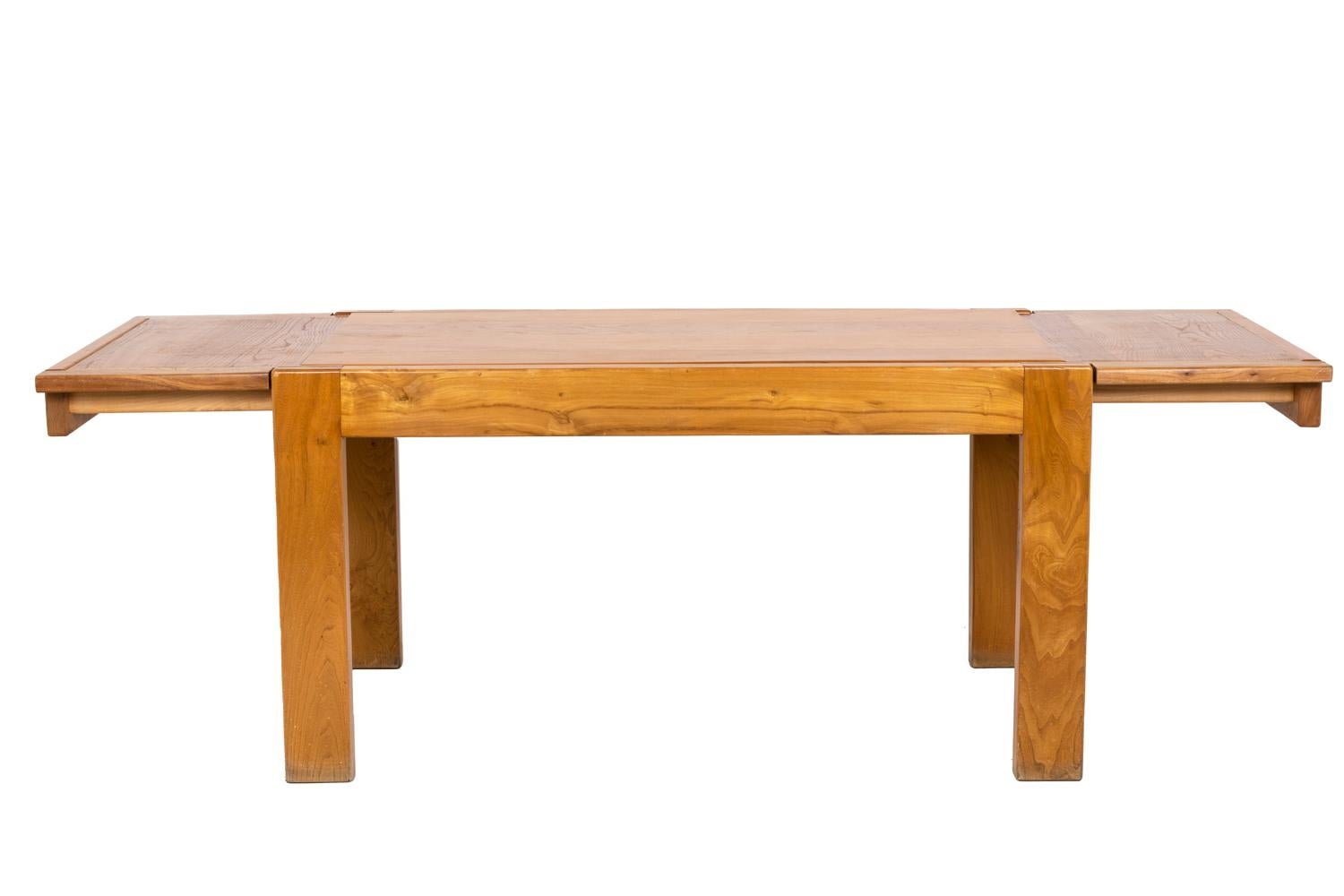 Maison Regain, attributed to.

Rectangular-shaped dinning table in blond elm composed by four rectangular cross-section feet linked by four high sleppers including two small removable ones allowding the installation of extensions. The elm pannel