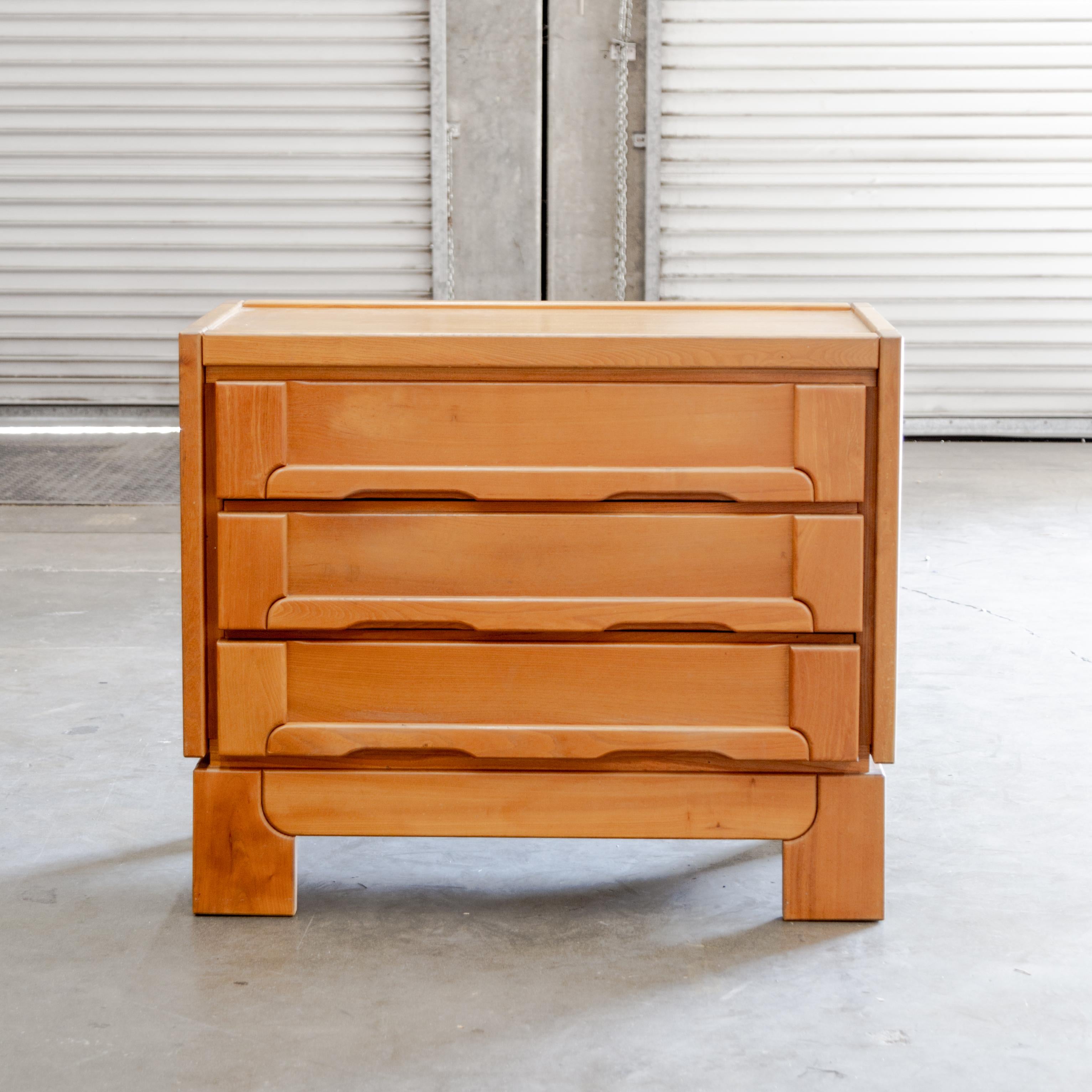 Commode à trois tiroirs en bois d'orme de la Maison Regain, avec détails d'assemblage exprimés et poignées de tiroir intégrées et sculptées, vers les années 1970 en France.
