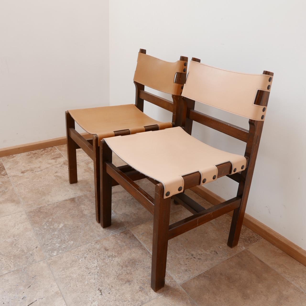 A set of four dining chairs by Maison Regain. 

Leather and stained elm. 

Some scuffs and wear to the wood commensurate with age, but generally they remain in good condition, the leather also remains in good condition. 

Two sets available at