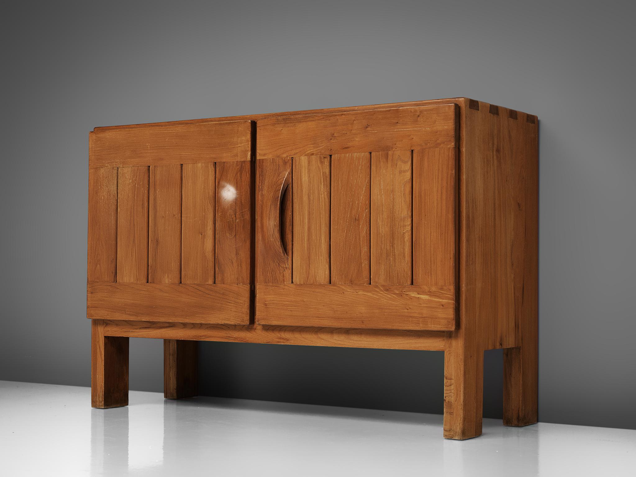 Maison Regain, credenza, elm, France, 1970s.

This exquisite credenza combines a simplified yet complex design combined with nifty, solid construction details that characterize Maison Regain's designs. The two well balanced, sturdy doors are