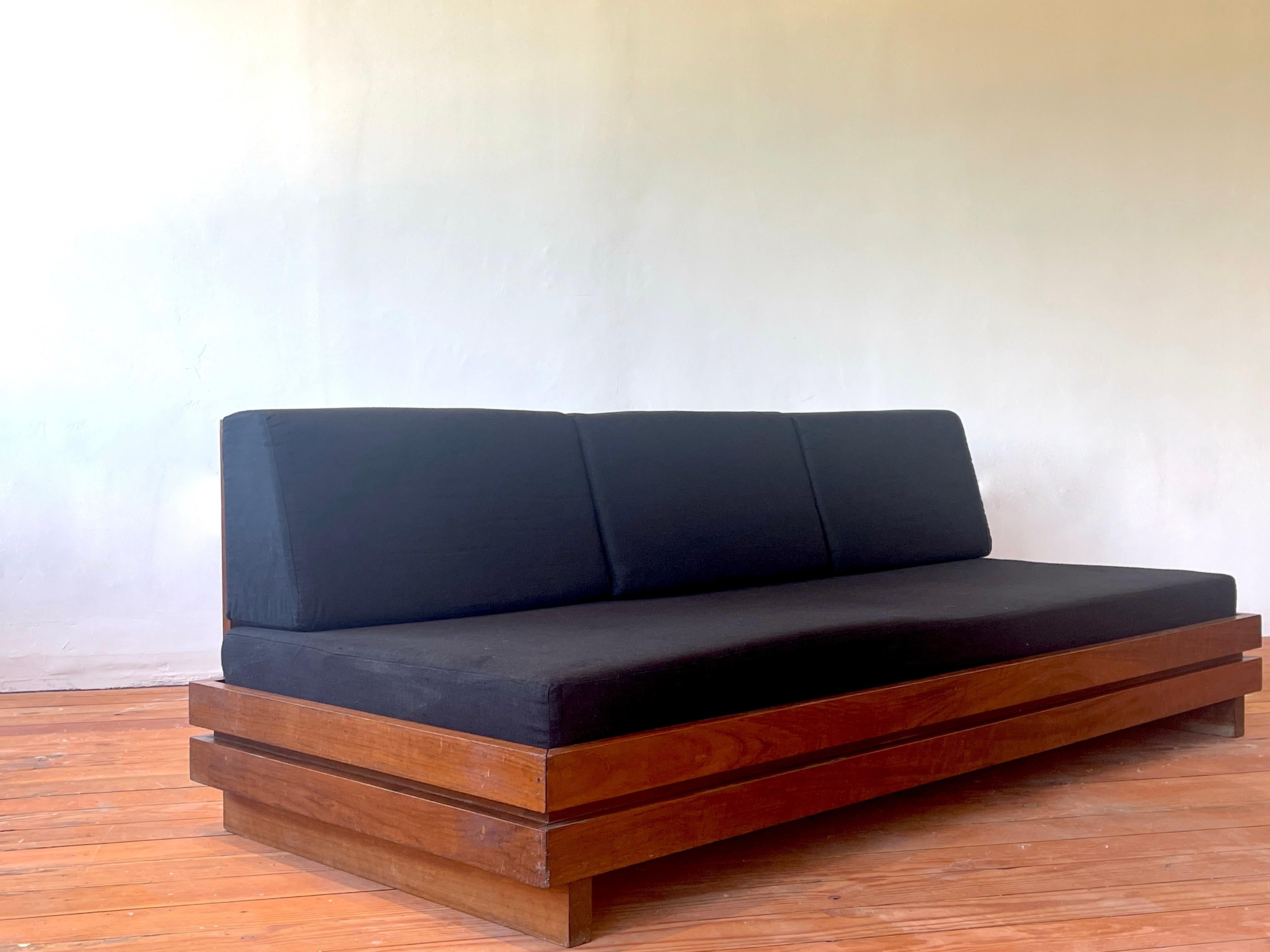 Large bench seat sofa produced in the 1970s by Maison Regain
Solid construction in elm wood reminiscent of Pierre Chapo. 
Beautiful grain to wood - simple lines
Newly upholstered seat and back cushion in black linen from France.