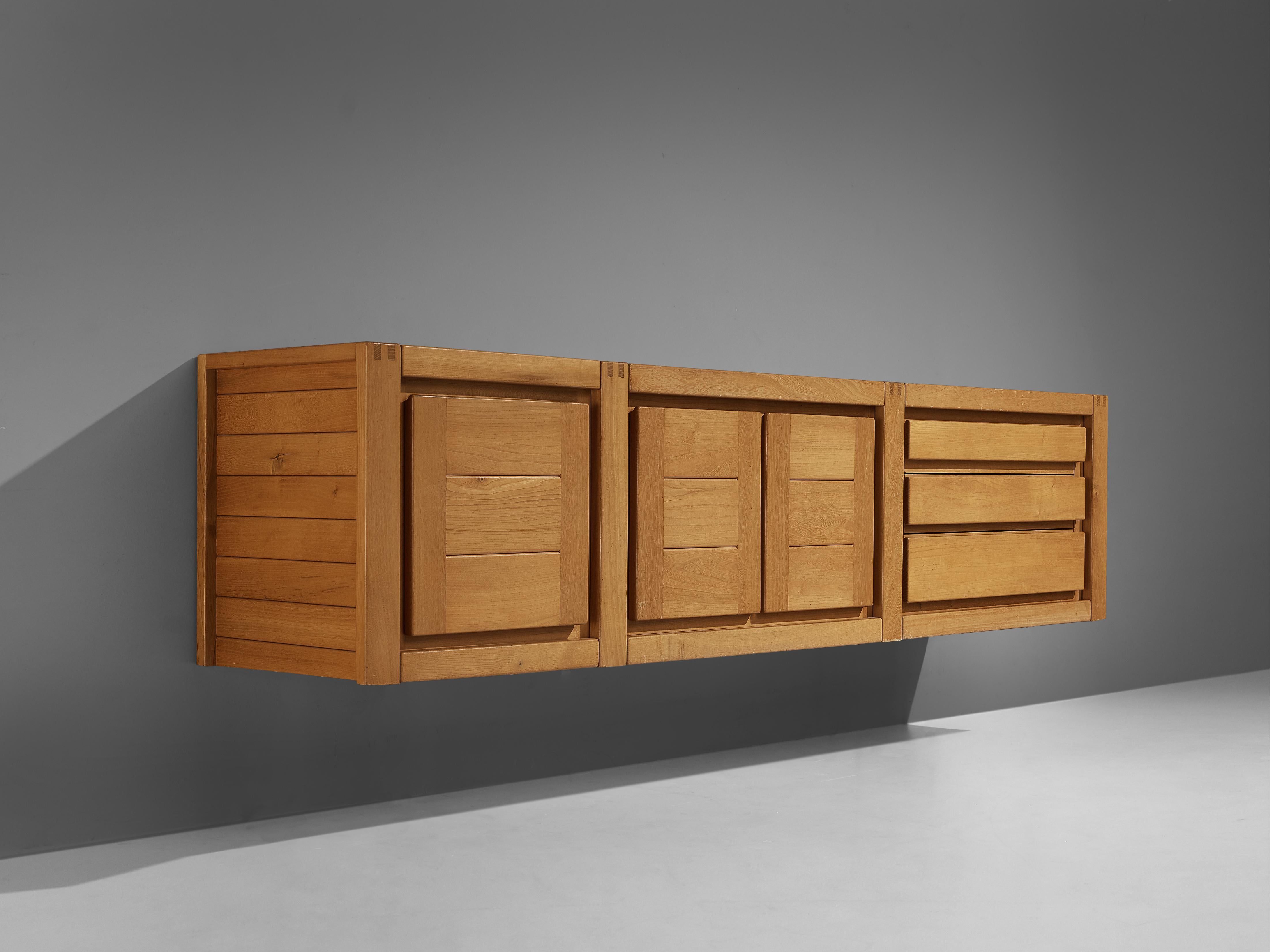 Maison Regain, wall-mounted sideboard, solid elm, France, 1970s

This sideboard by Maison Regain has a strong decorative look. It is clearly structured in three compartments. Three drawers on the right and one single door on the left accompany two