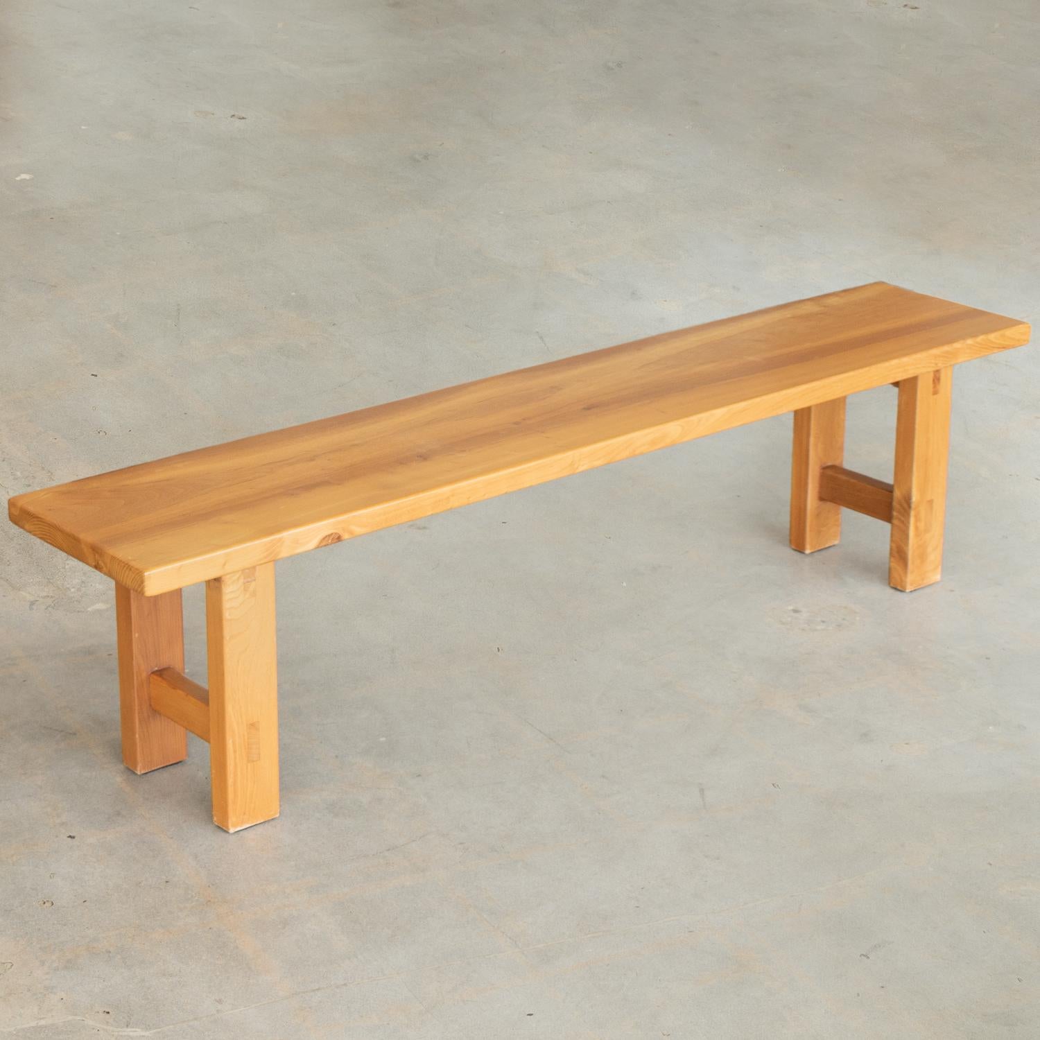 Great long wood elm bench from France by Maison Regain with light wood plank seat and solid wood legs. Original wood finish showing great age, patina, and wear.