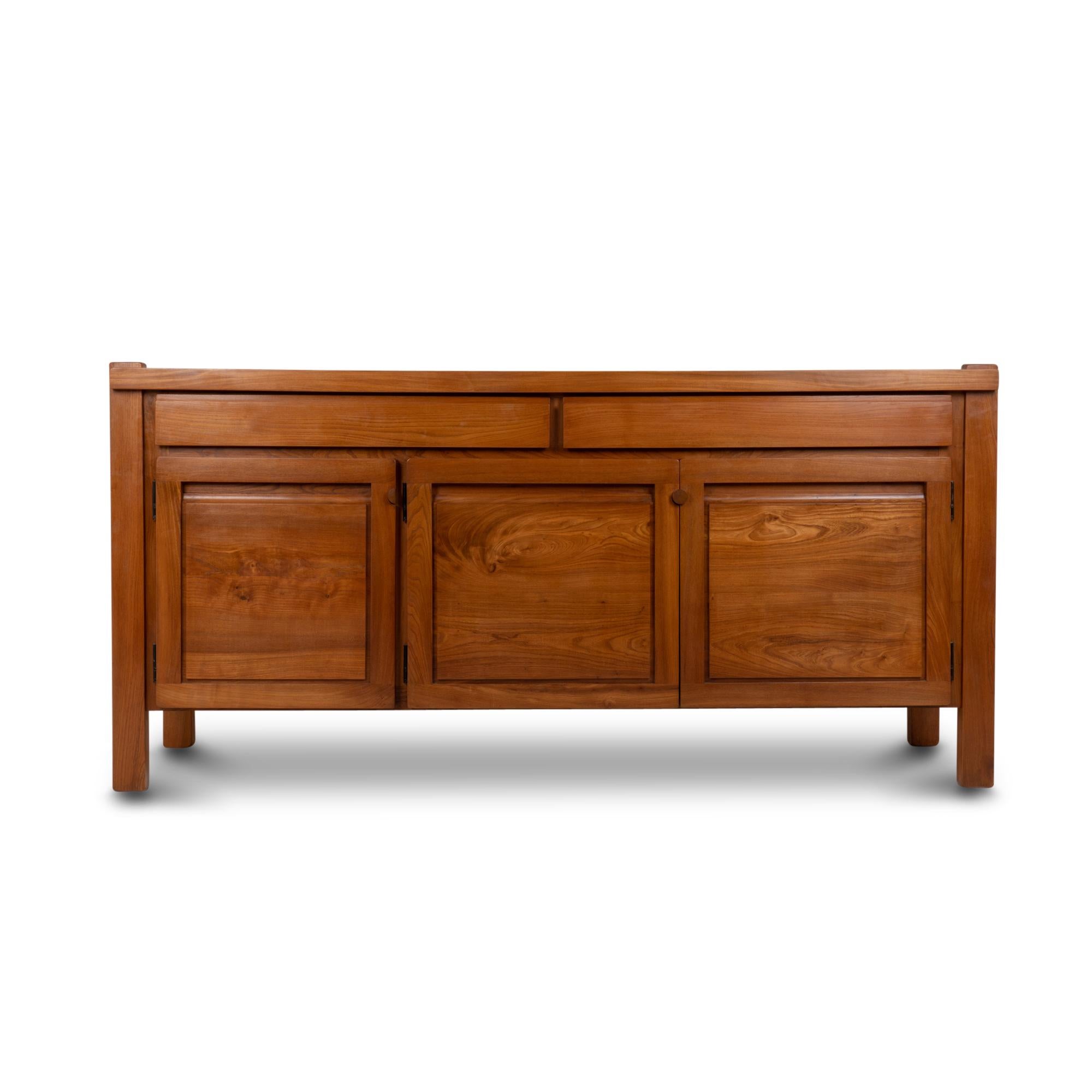 Sideboard in blond solid elm, opening with three doors and two drawers in front. Original compartmentalized cutlery tray in the right drawer. Small circular handles.

French work realized in the 1960s.