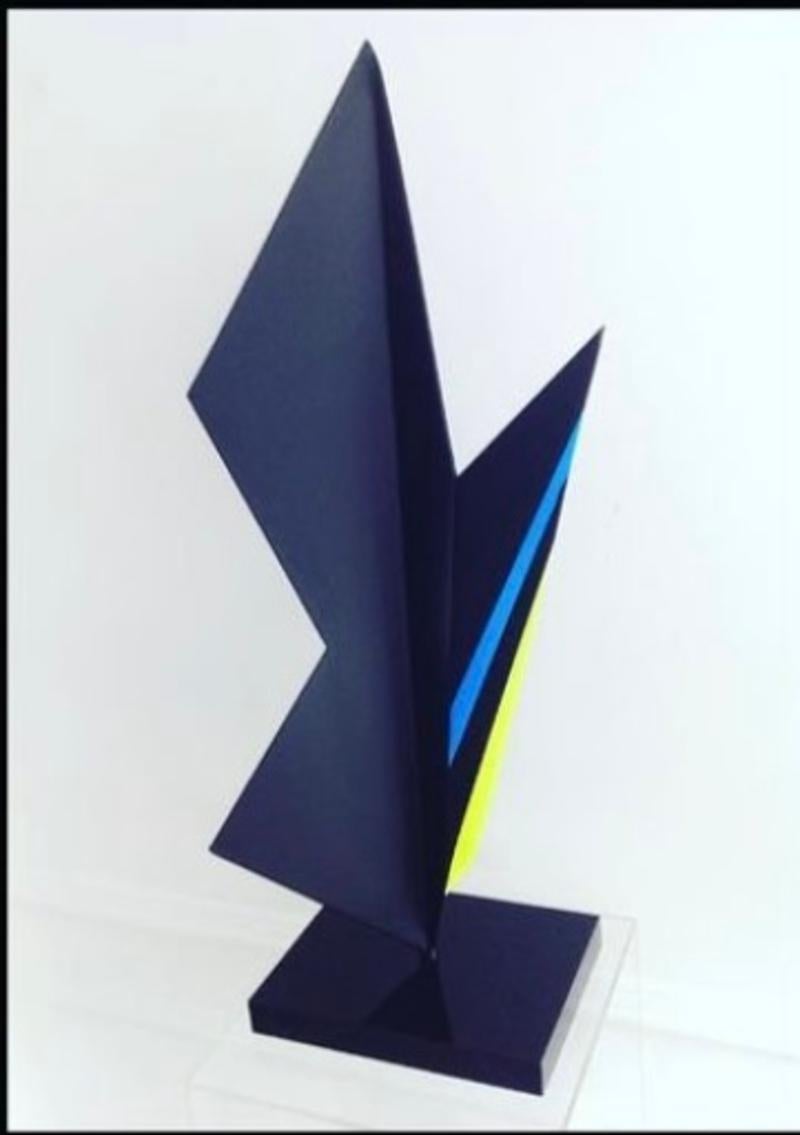 Black sculpture with yellow and blue flúor stripes.
Sheet metal bending recalling a lightning bolt in motion.