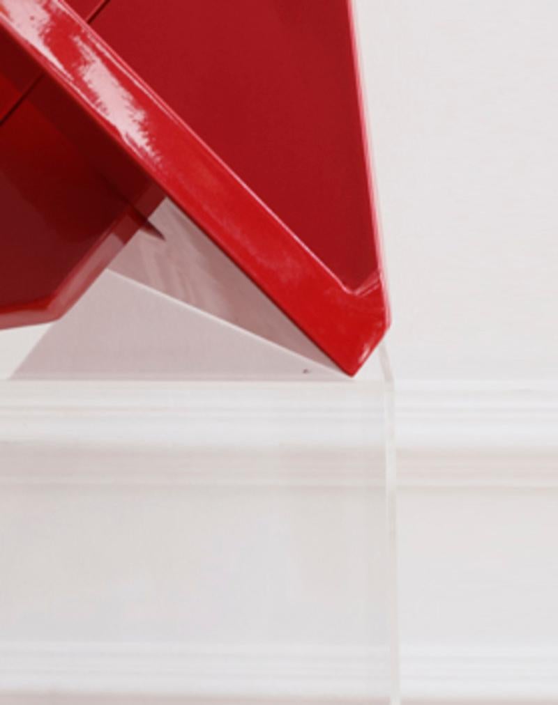 Red arrow sculpture. Geometry wrapping a space with a los of harmony.