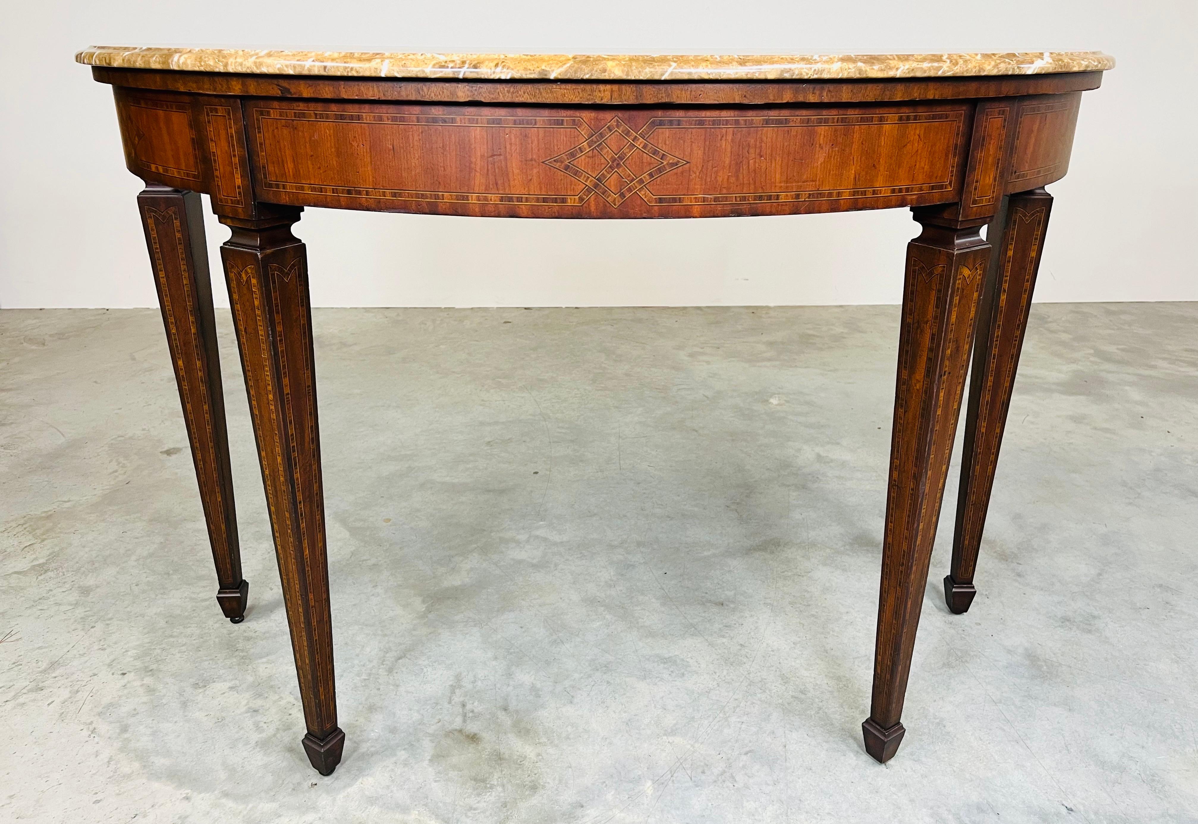 A stunning Demi-lune table by Maitland Smith in the Adam style having beautiful parquetry inlay throughout with tapered legs and stone granite top. 
In excellent condition. Wood has been cleaned and treated for longevity. 
35x52x21.5” HWD 