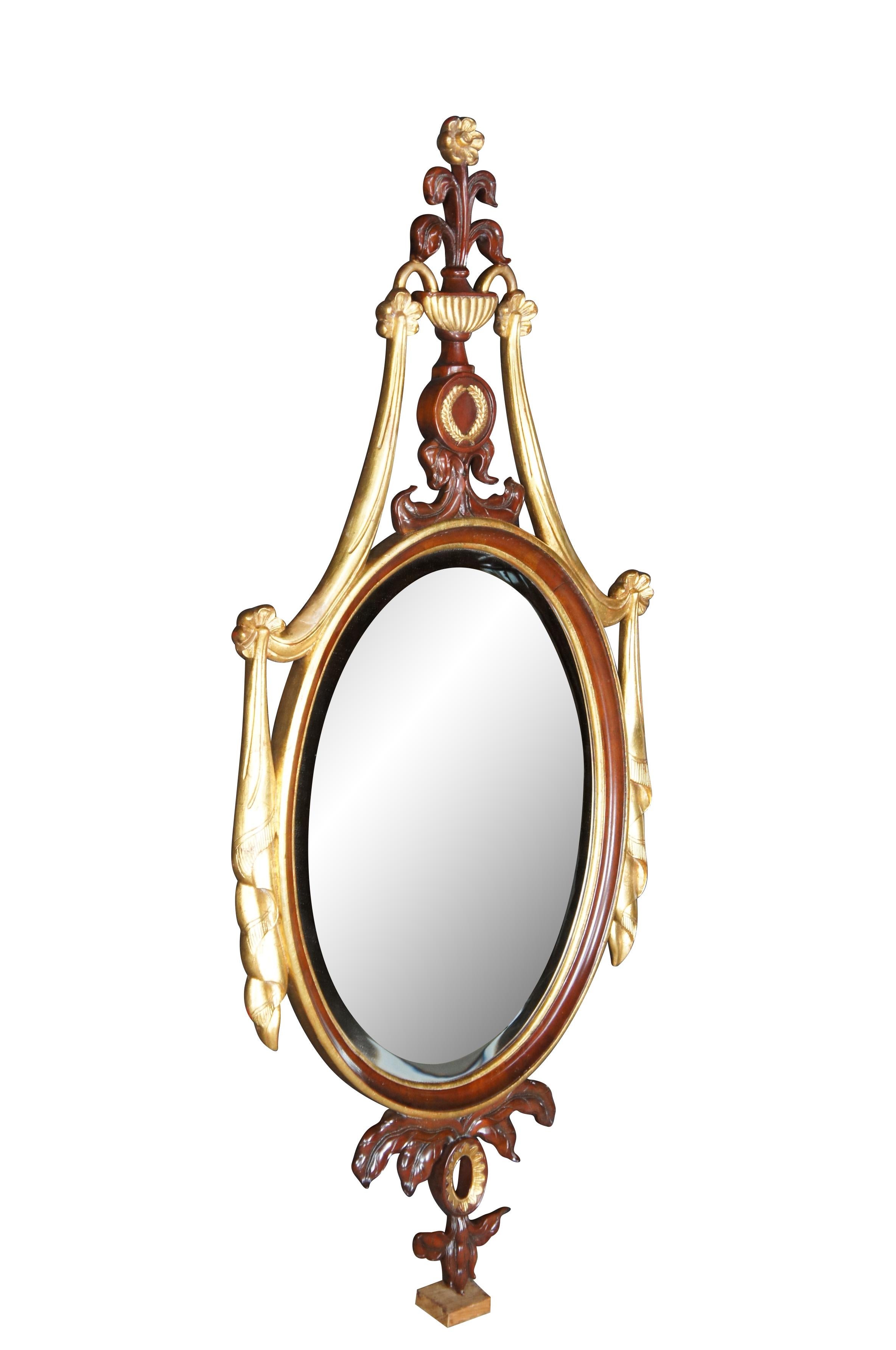 1990 Miroir mural de style Adams.  Fabriqué en acajou sculpté avec un cadre doré. Centre ovale en verre biseauté entouré de guirlandes néoclassiques.   La couronne en miroir présente une urne grecque avec un médaillon de fleurs et de couronnes.  Un