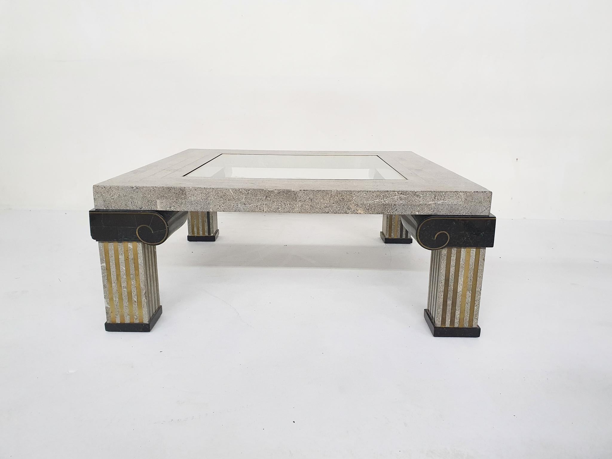 Stone coffee tables with brass inlay attributed to Maitland-Smith.
Glass top has a small chip from the corner.