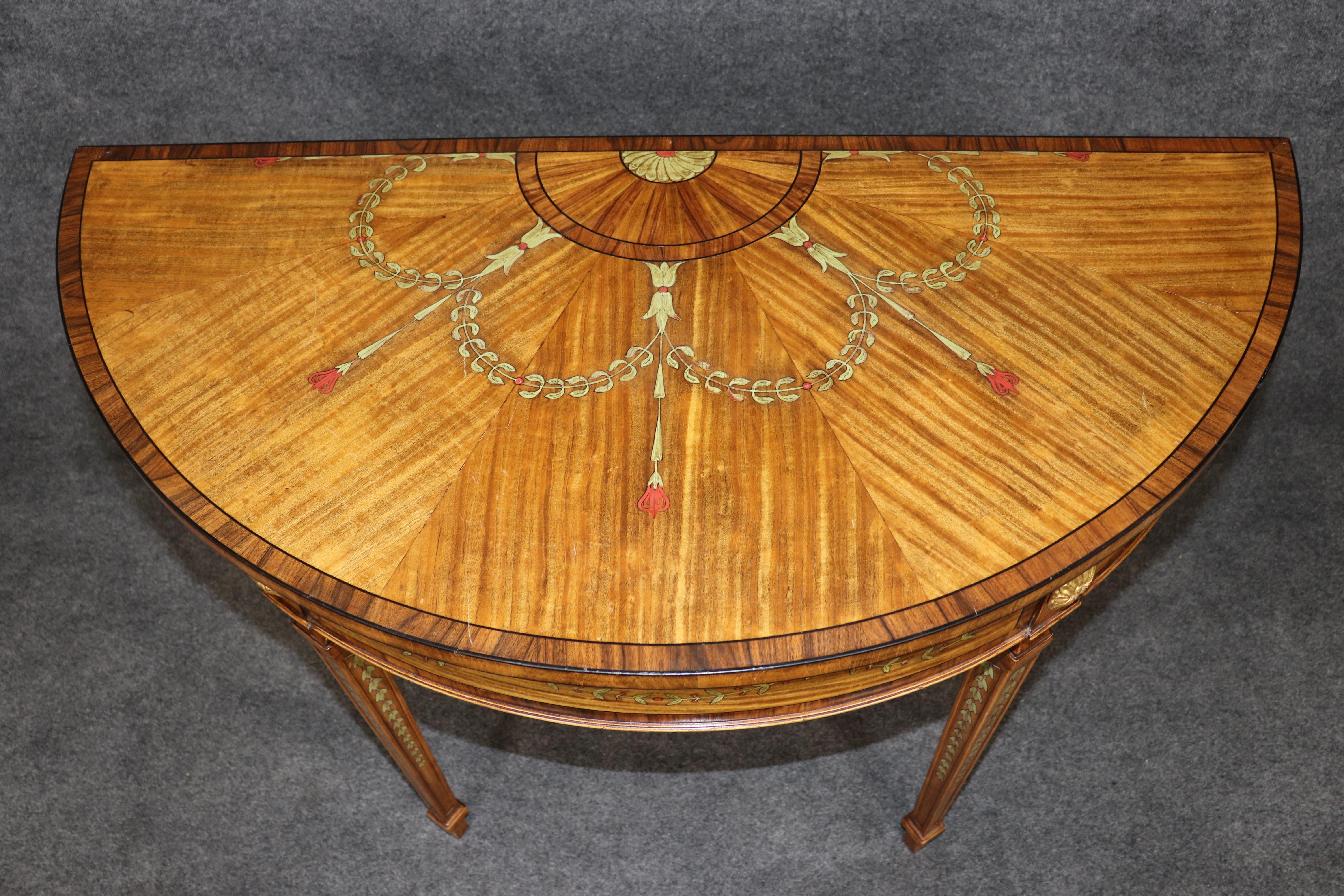 This exquisite Adams style demilune satinwood console table reflects the refined craftsmanship and classical beauty of late 18th-century English design. The table features a rich satinwood veneer with hand-painted decoration throughout, including