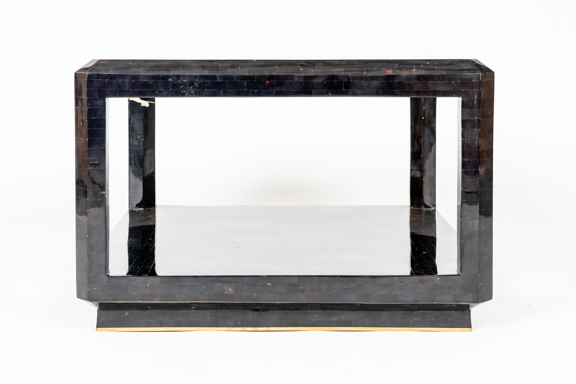 Cette magnifique table d'appoint manufacturée de Maitland Smith montre le travail délicat avec des matériaux comme la mosaïque de coquillages. La structure est recouverte de petites pièces rectangulaires de mosaïque de coquillages de couleur foncée