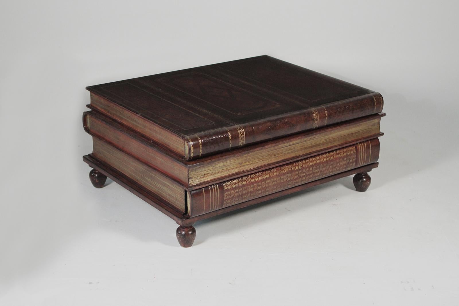 Maitland-Smith stack book coffee table. The leather wrapped surface with three concealed drawers. Each book is a drawer with on the front and two on the back. The hand tooled leather with gilt edges is in a warm cognac color. This piece is in