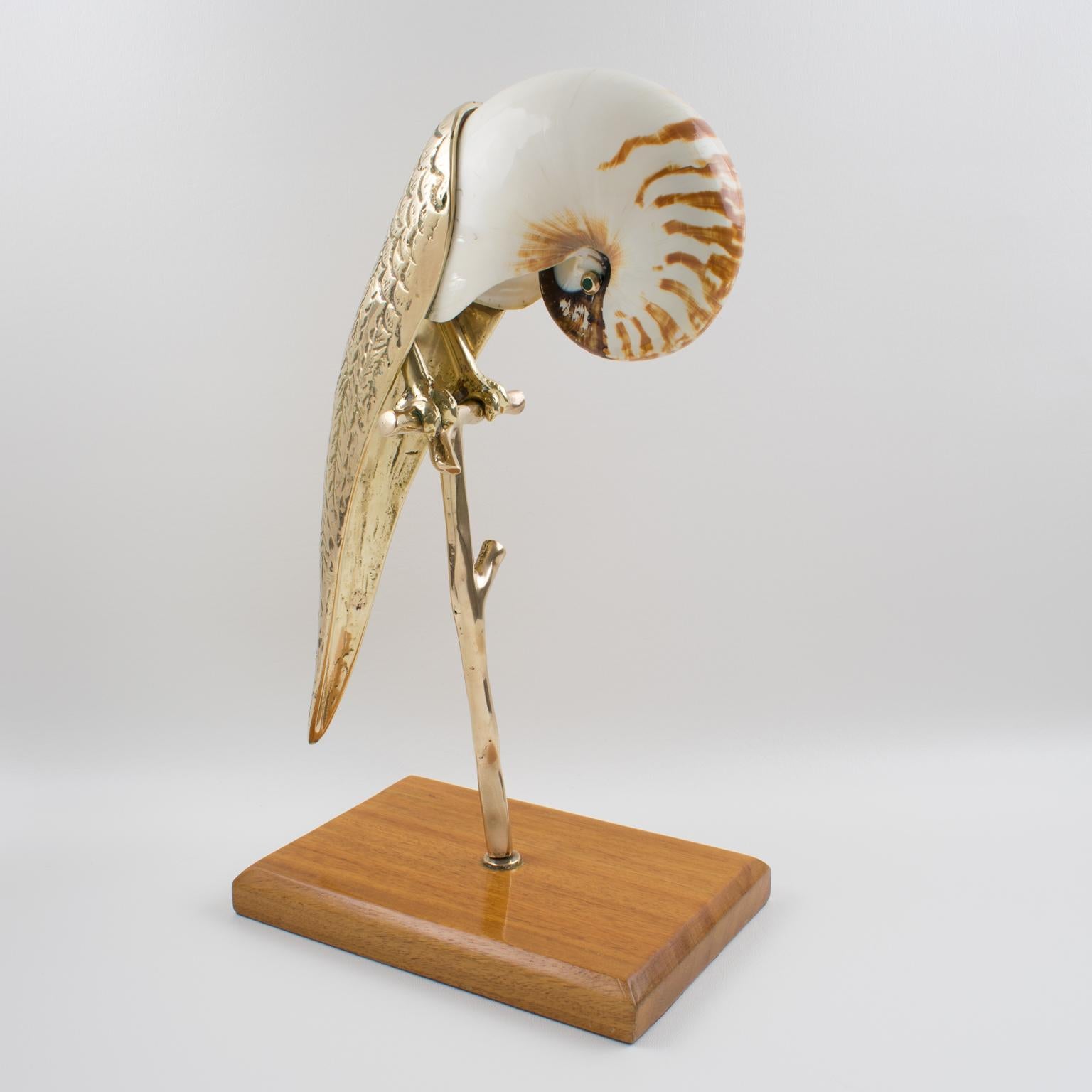 Beautiful sculpture by Maitland-Smith, featuring a parrot bird. The bird is made of polished solid brass with refining detailing and nautilus seashell. The bird also has a precious Malachite stone eye on each side. The bird stands on a solid brass