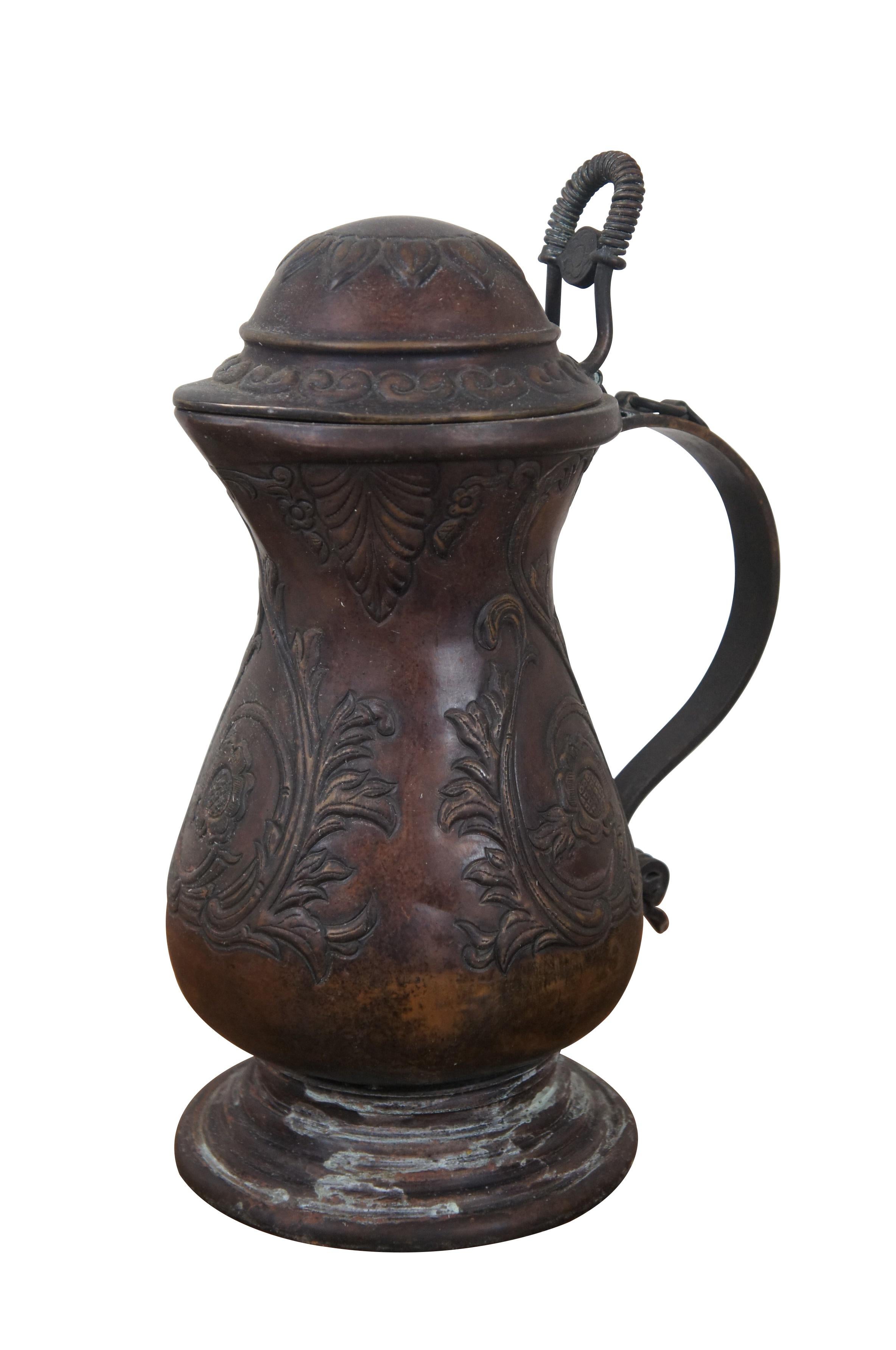 Rare Maitland Smith brass flip top jug / pitcher / flagon, with dark patina, scrolled handle and embossed with a design of swirling leaves, roses, and sunflower on the lid. 

Dimensions:
8.5