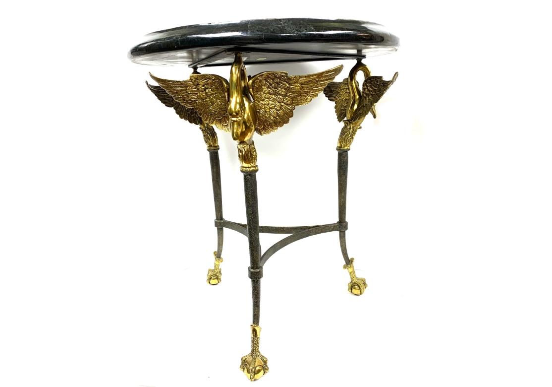 Table à plateau en marbre tessellé de Maitland Smith à décor incrusté de pétales de fleurs, surmonté de trois cygnes à ailes ouvertes en laiton bien coulé. Le cadre en fer, dont la finition texturée rappelle le style brutaliste, est relié à un