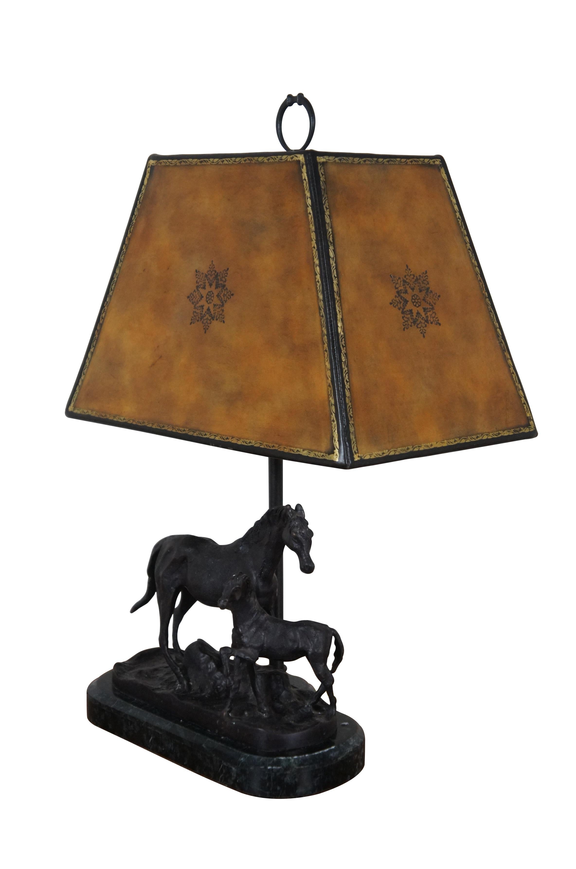 Late 20th century figural horse bronze table lamp by Maitland Smith featuring a mare and foal in tableau on a charcoal black marble clad base. Includes hard and rectangular tooled / gilded leather shade with foiled interior. Horse bit shaped finial.