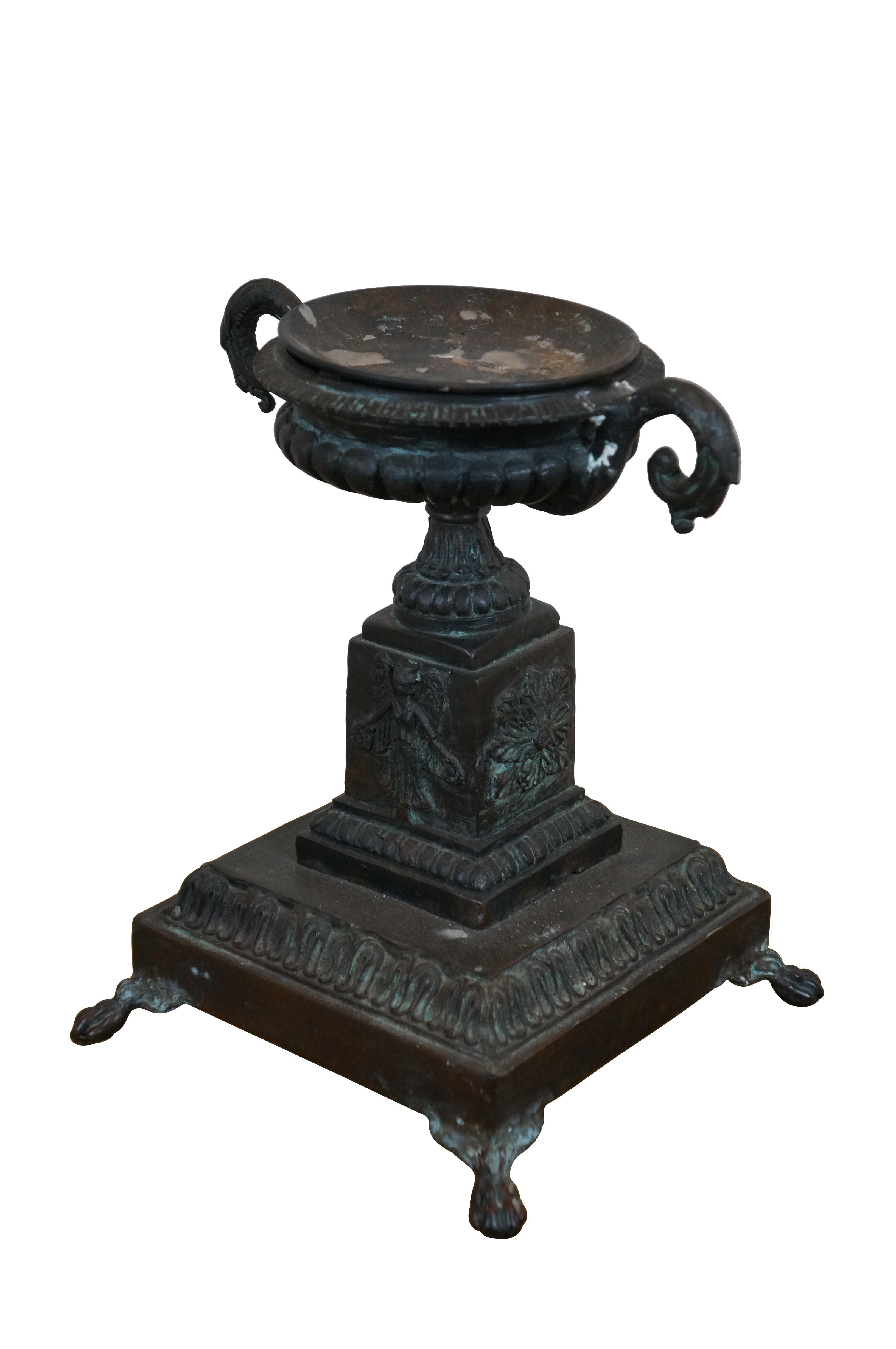 Portacandele a colonna in bronzo di Maitland Smith della fine del XX secolo in stile neoclassico / Grand Tour / tazza. Base quadrata con piedi a zampa che sorreggono un piedistallo decorato con angeli / Nike alate e fiori, sormontato da un'urna