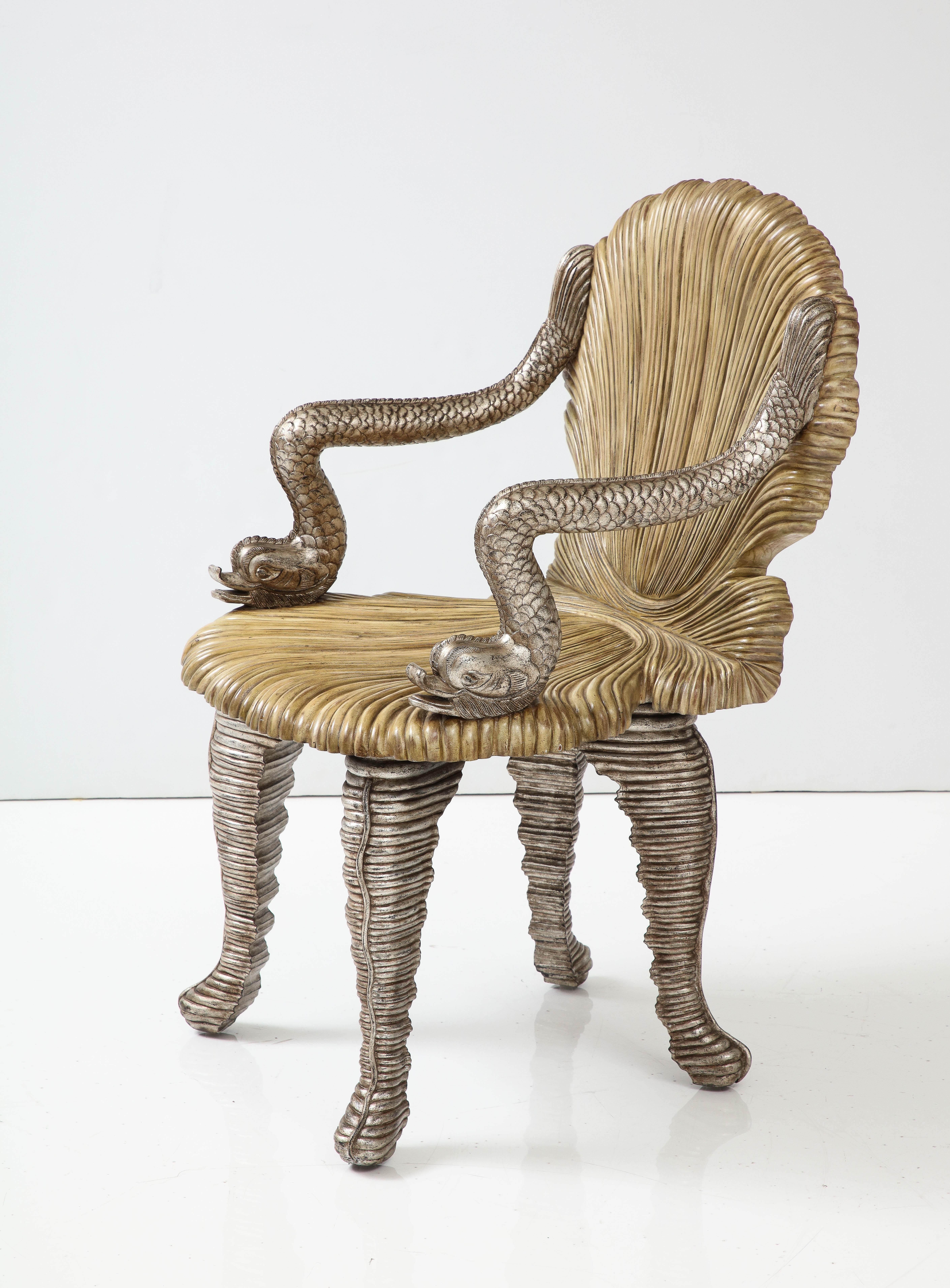 Wonderful carved grotto chair by Maitland Smith.
A Pair of silver leafed dolphins sit either side of the carved seat and chair back
and are supported by silver leafed rouged legs.