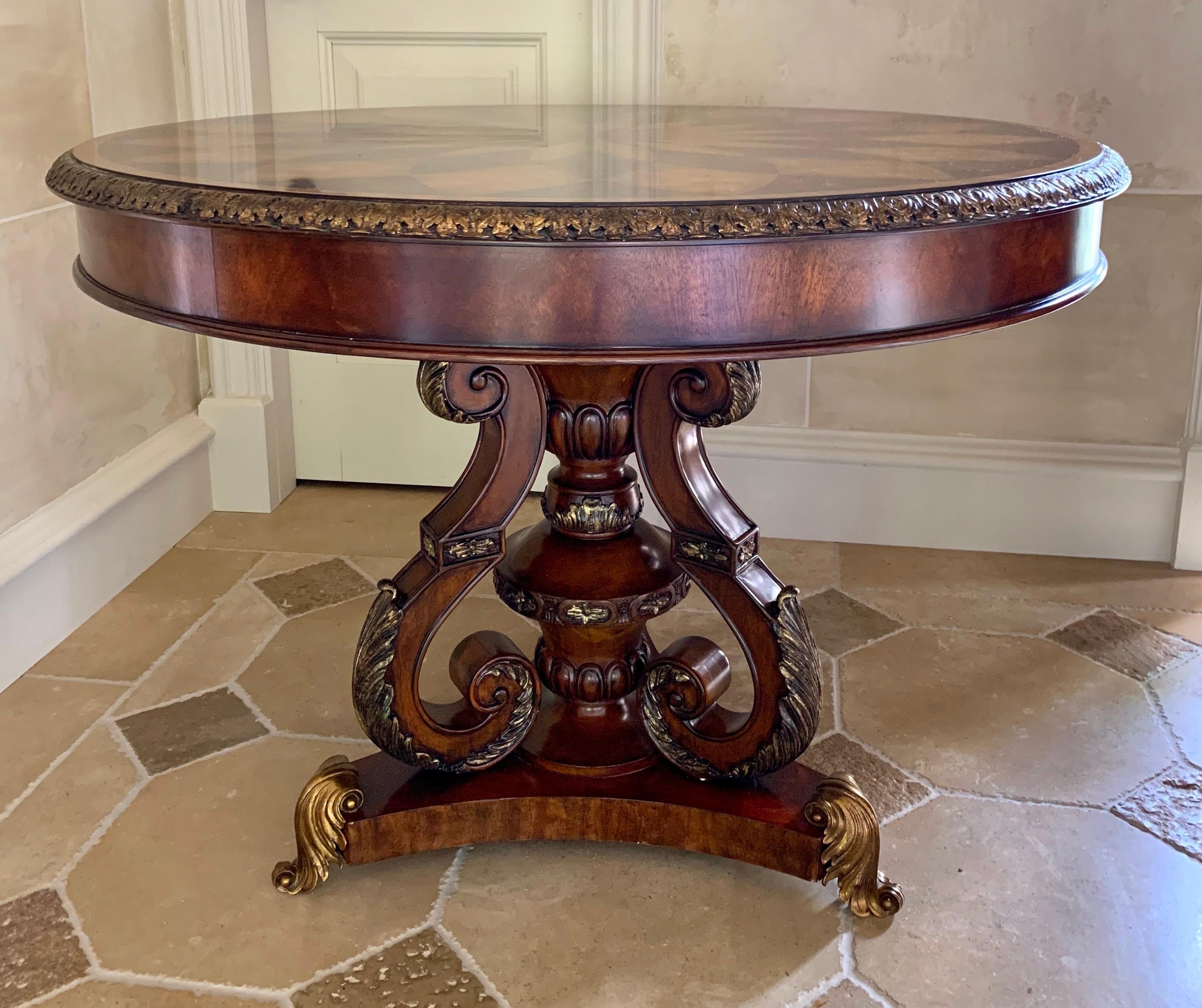 Exquisite Maitland Smith round center pedestal table features a marquetry star pattern on top and carved gold giltwood accents and border.