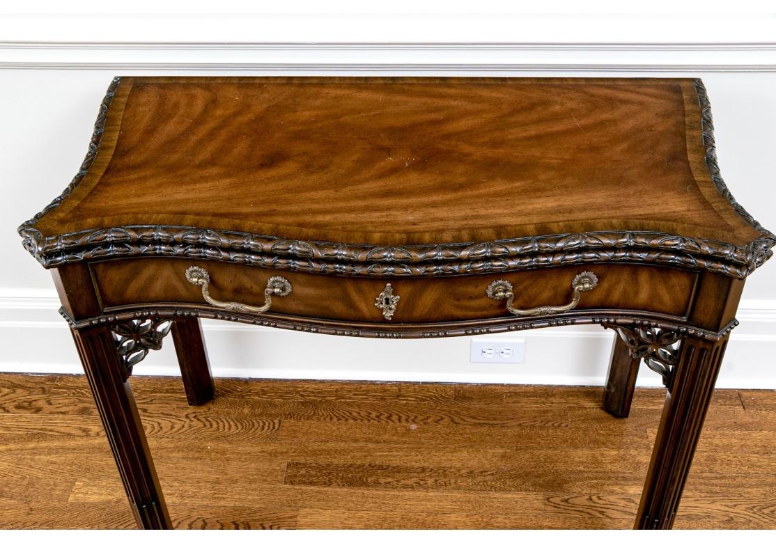  Maitland-Smith games table in Chippendale style, veneered in beautiful medium brown along a serpentine top with cut-corner flourishes. Features a hinged top opening to a teal felt lined surface. The rim around the top is finely carved and