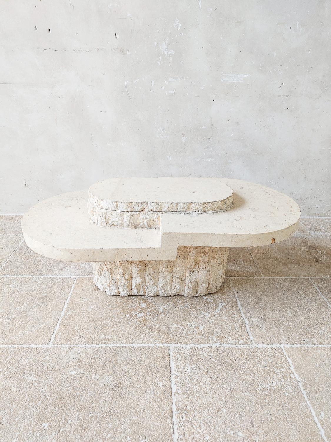 Vintage Magnussen Ponte cocktail table with travertine veneer and inside 3 bottle holders, 1970s, Hollywood Regency.

This cocktail table or coffee table has an oval kind of shape, with in the middle a faux tree trunk feature with 3 surfaces of
